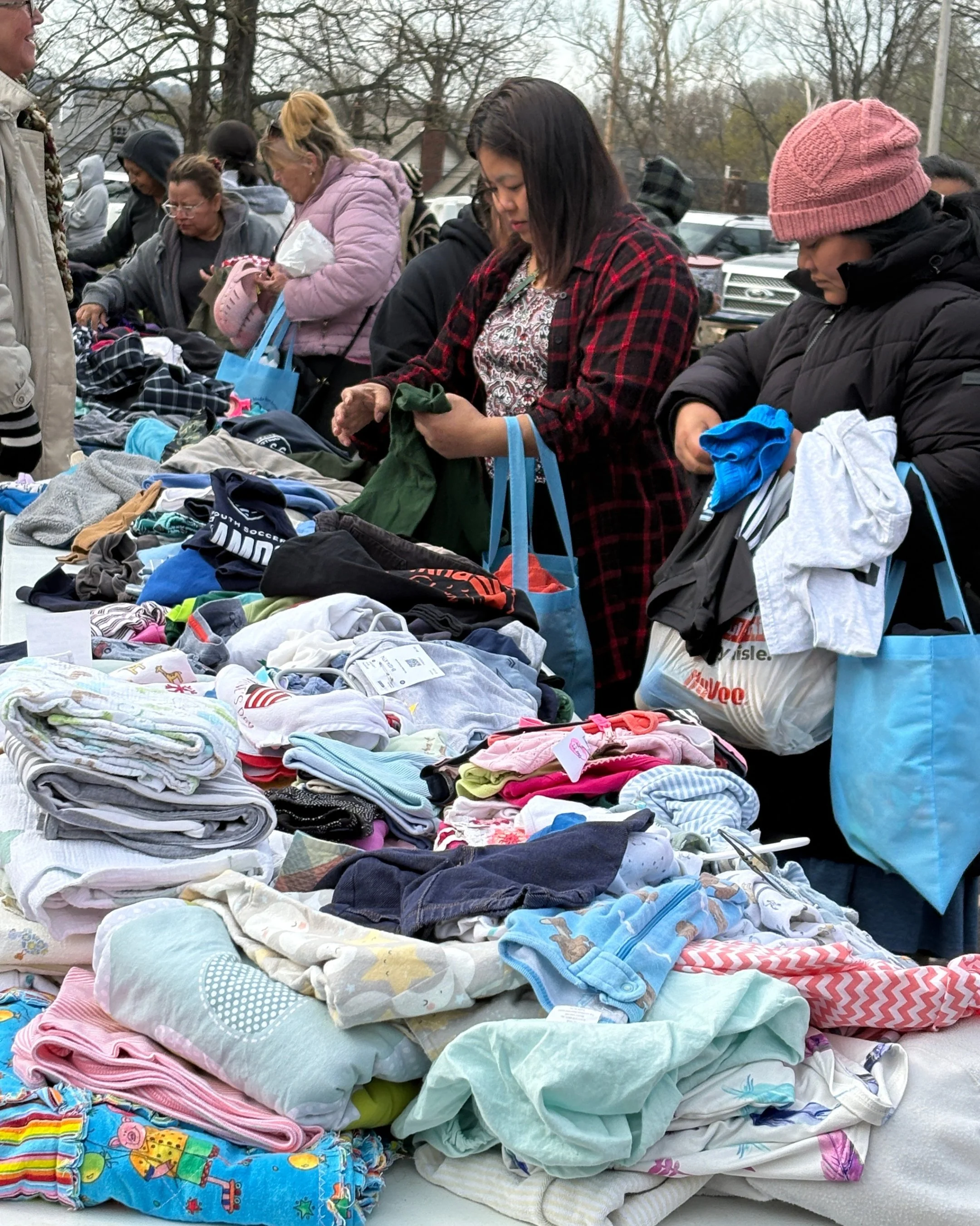 Women choose clothing and receive free goodie bags at Mercy & Truth's F.I.R.S.T. Tuesday event in Kansas City, KS, during Stress Awareness Month.