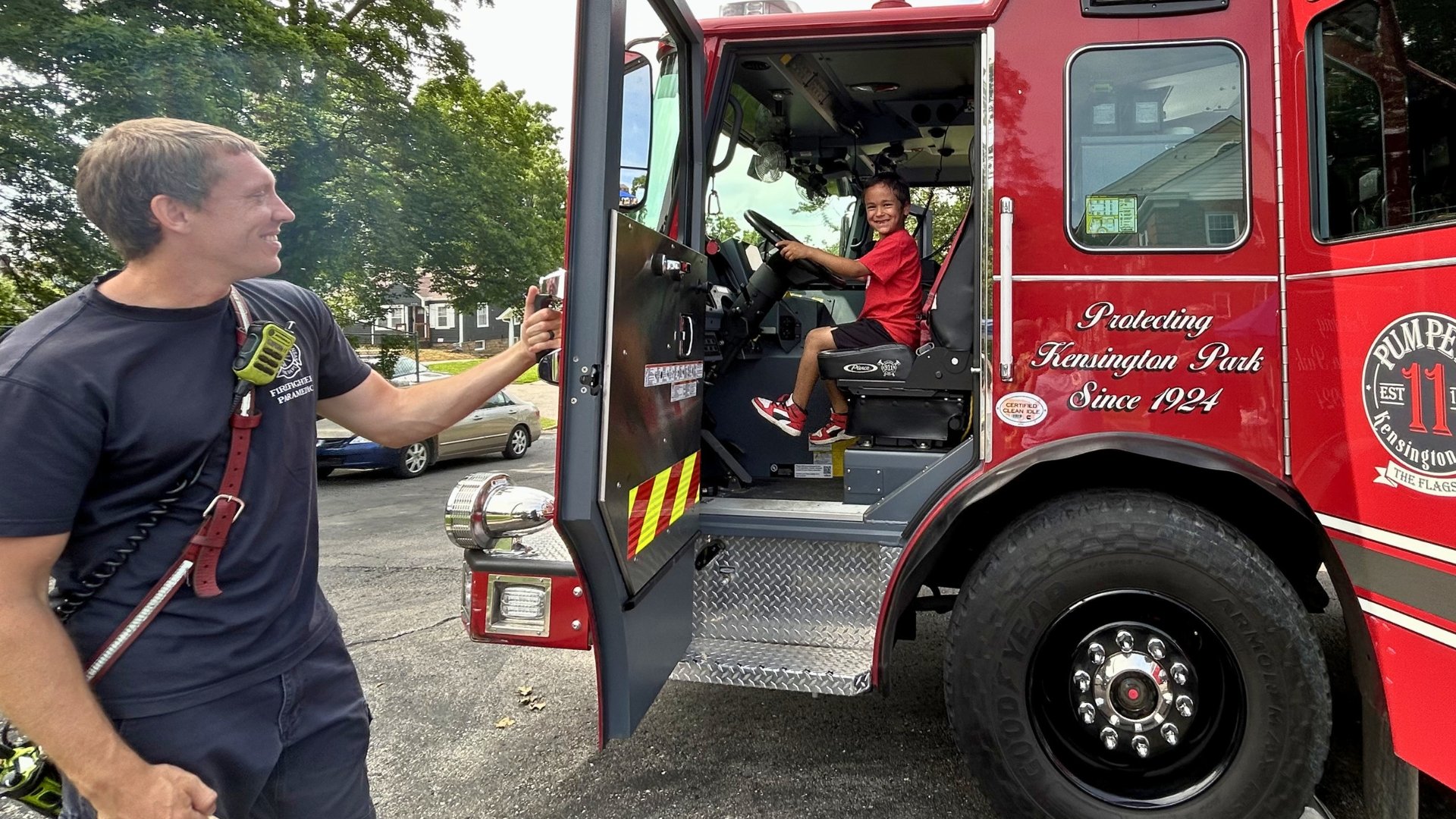 Child enjoys meeting with firefighter as part of free community fun at Mercy & Truth Healthcare Ministry in KCK. 