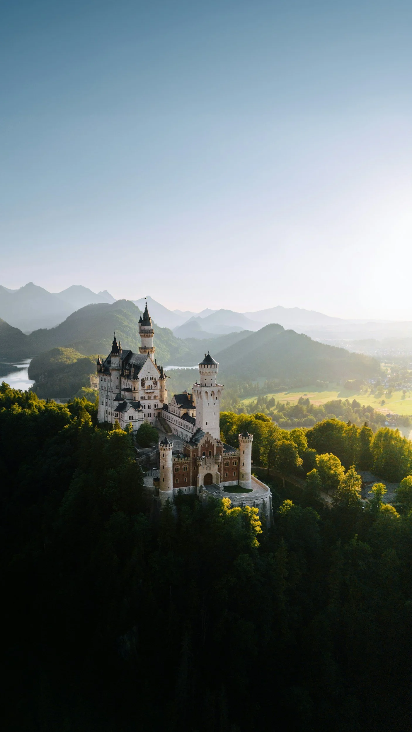 Paris street scene with  VRAI PARIS Montmartre cafe, blooming pink flowers, pedestrians walking, cars on cobblestone street, cloudy sky, historic buildings.