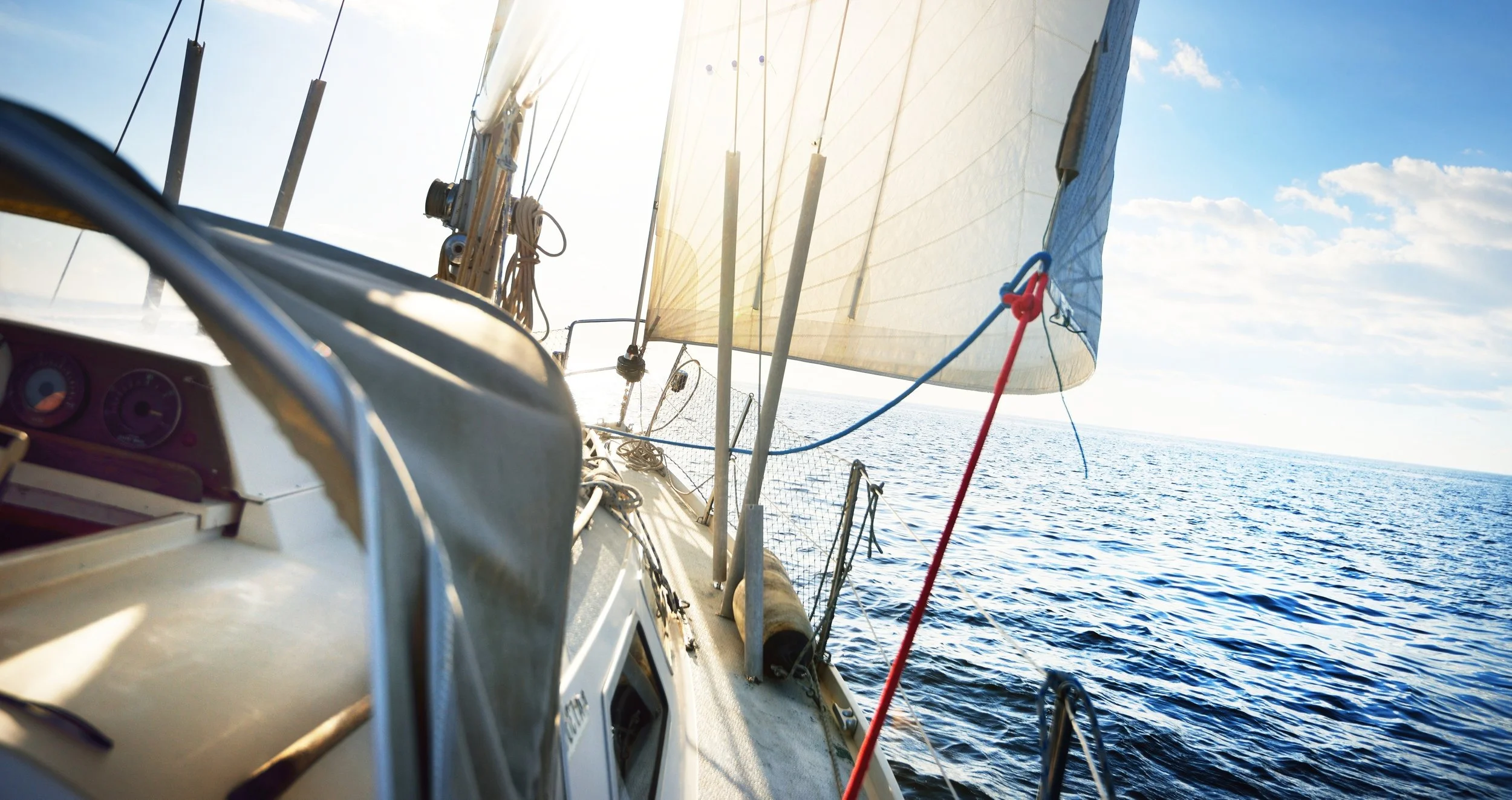 Summer sailing with sunlight through the sail