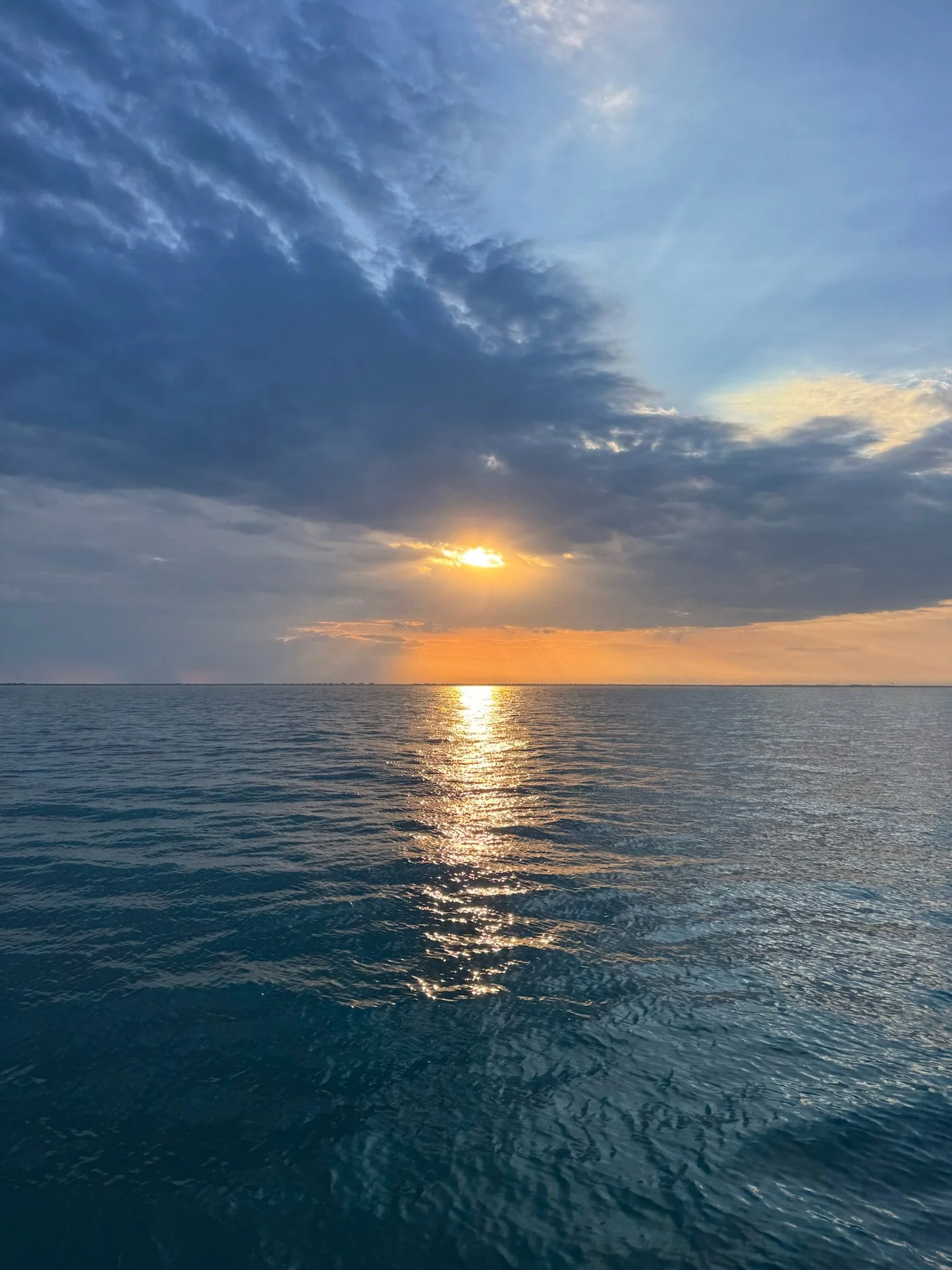 Guests aboard a private catamaran watching the sunset over Lake Michigan.