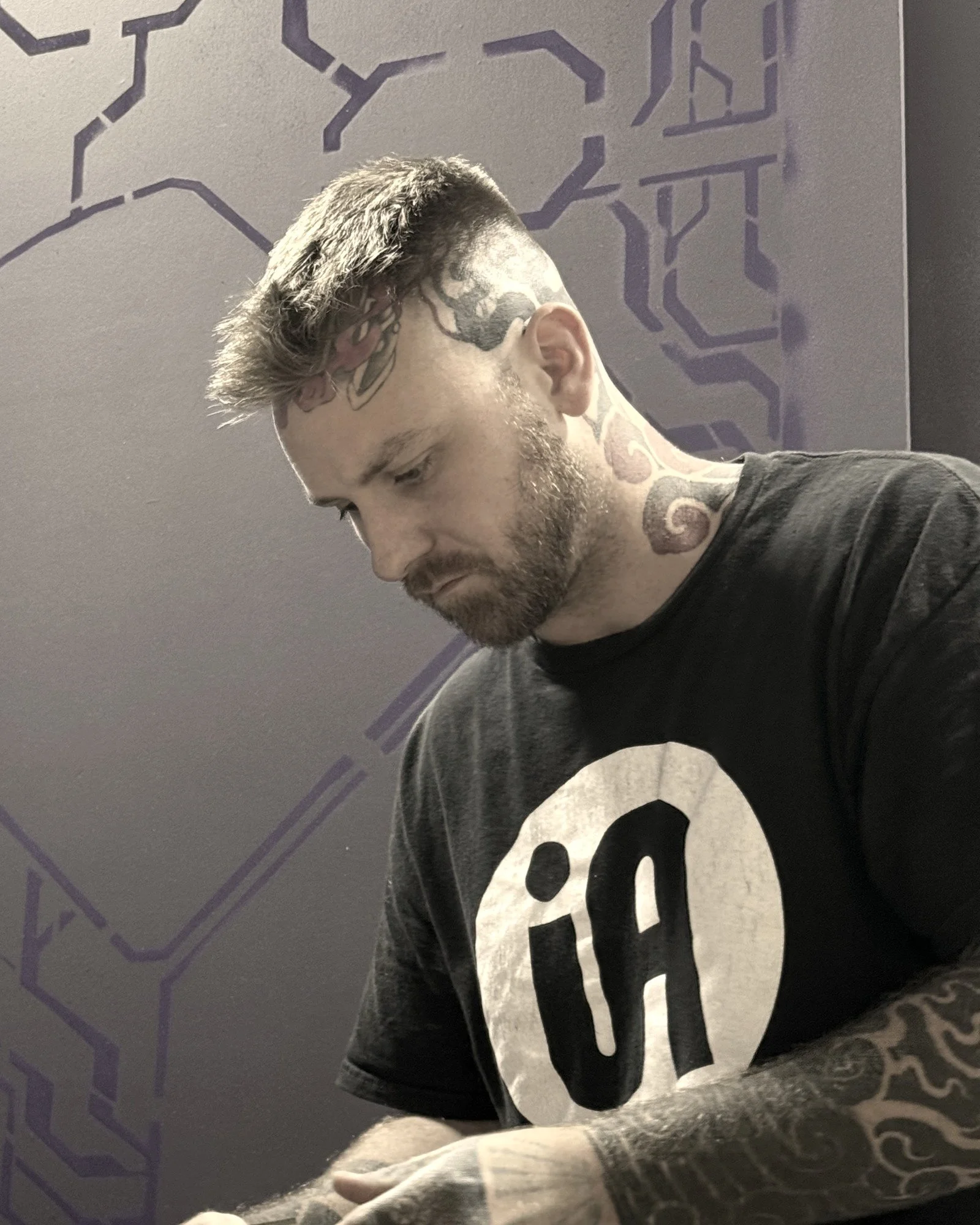 Chase Hanna, founder of Interlock Arts, examining a laser-cut plywood part in the studio.