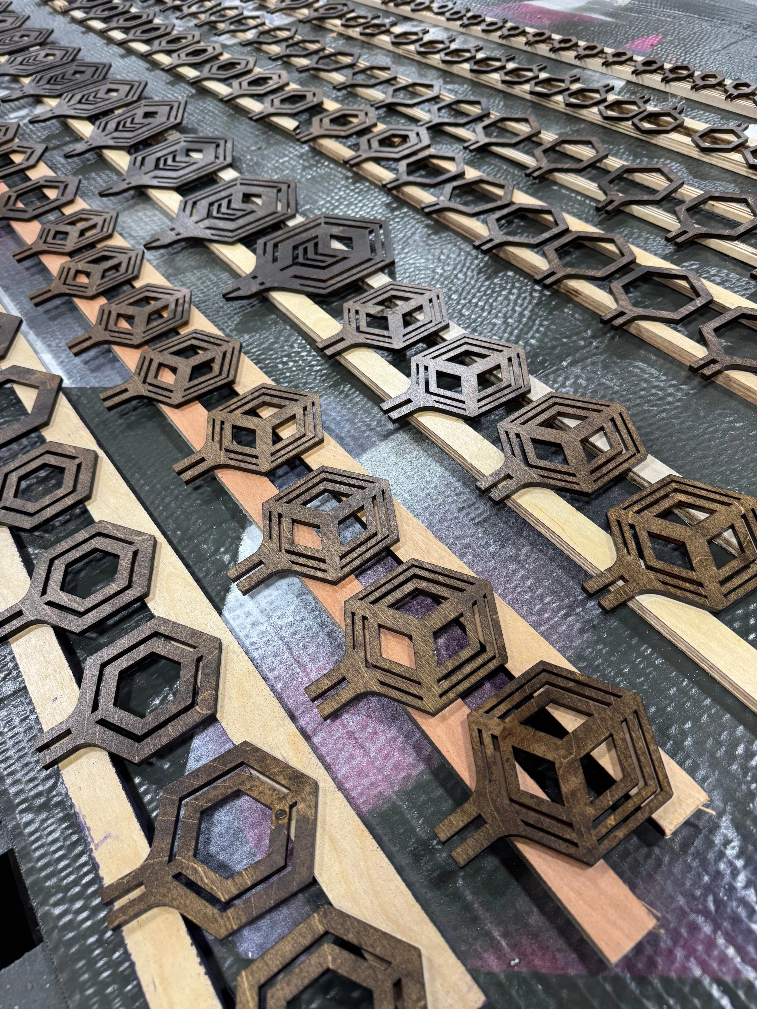 Laser-cut hexagonal birch plywood components nested on the bed in the Interlock Arts shop, Moodus, Connecticut.