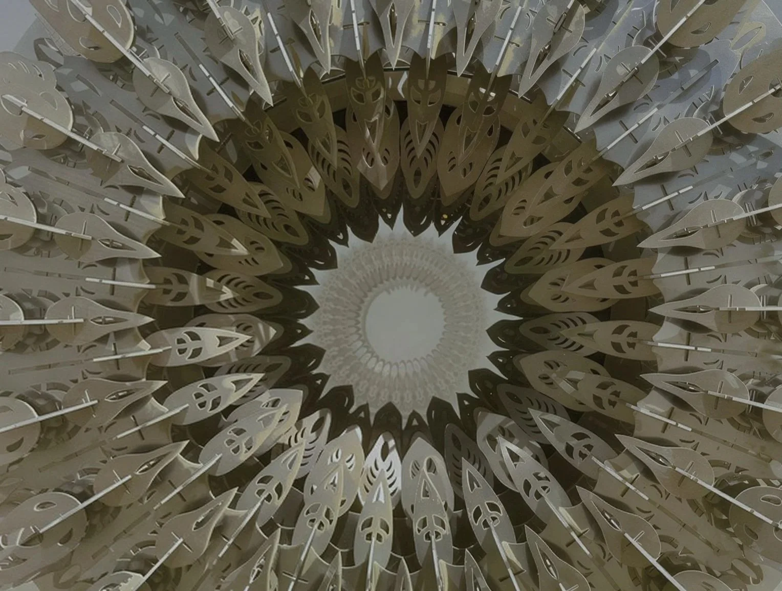 Head-on view into the center of the Burning Man ring sculpture, hundreds of laser-cut petals radiating outward from a pale disc at the core.