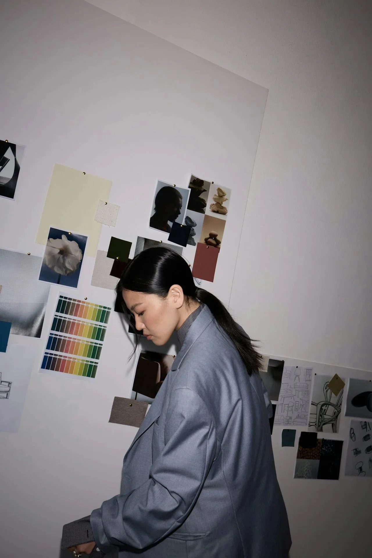 Asian American woman in a moment of quiet reflection at a desk.