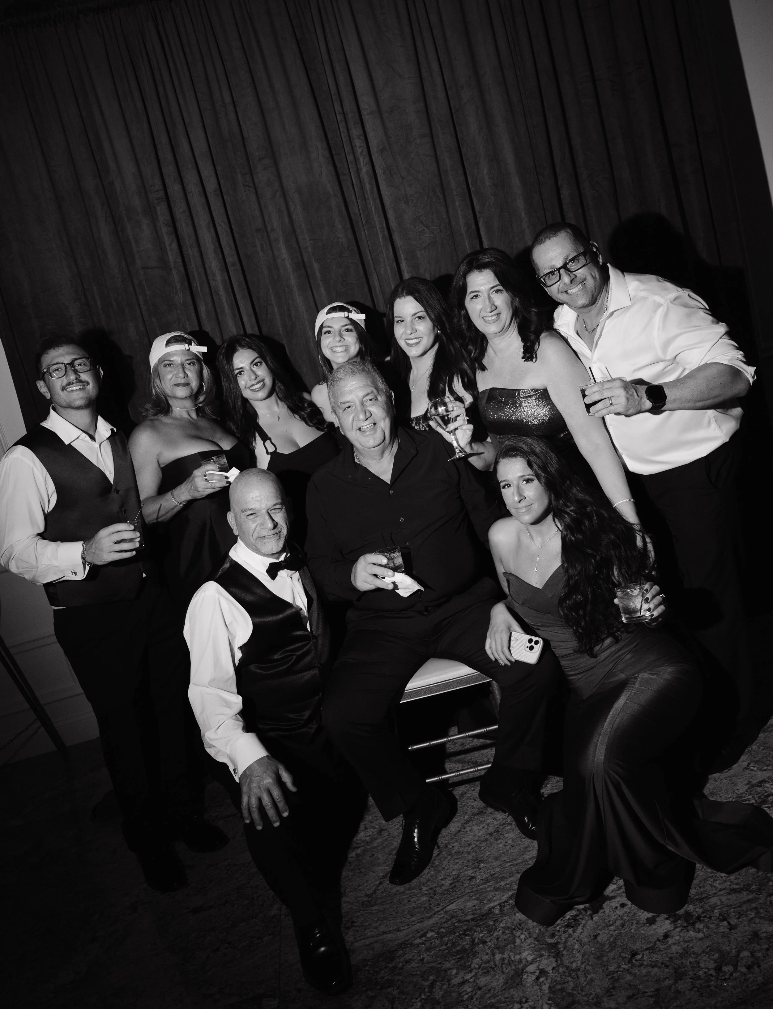 Black-and-white editorial guest portrait at a New Jersey wedding, featuring a guest in black tie attire posing against a dramatic dark curtain during Parado Studios’ wedding and event portrait experience.