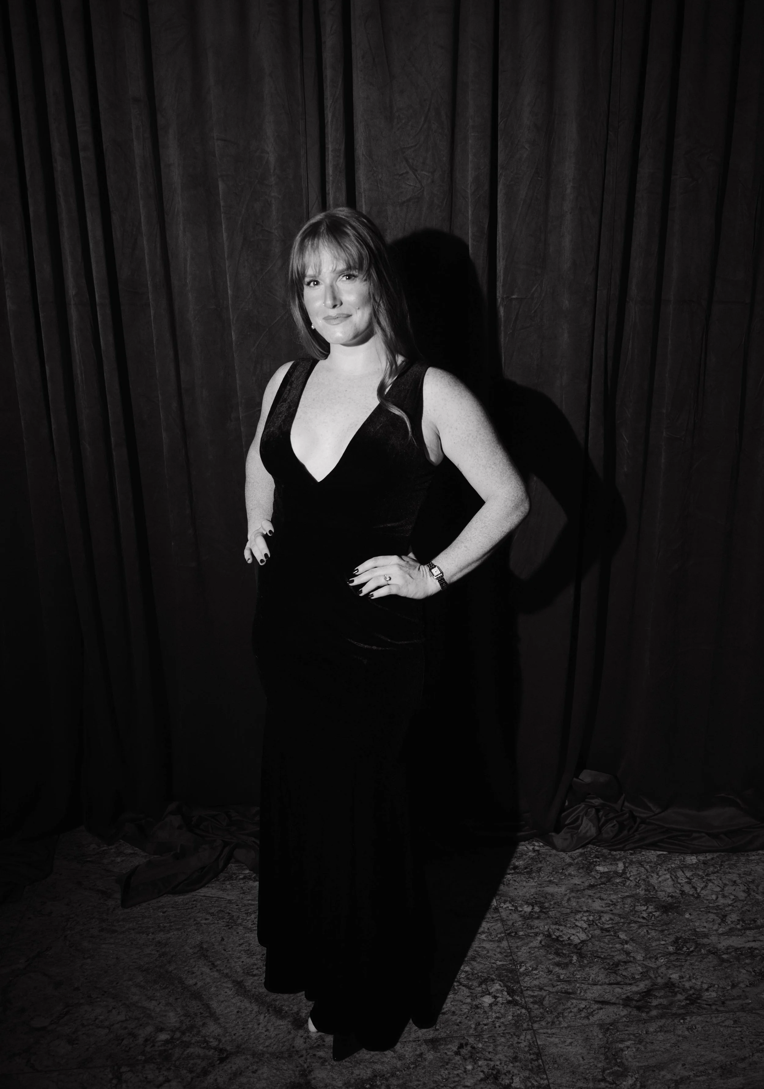 Black-and-white editorial guest portrait at a New Jersey wedding, featuring a guest in an elegant black evening gown posing against a dramatic dark curtain during Parado Studios’ wedding and event portrait experience.