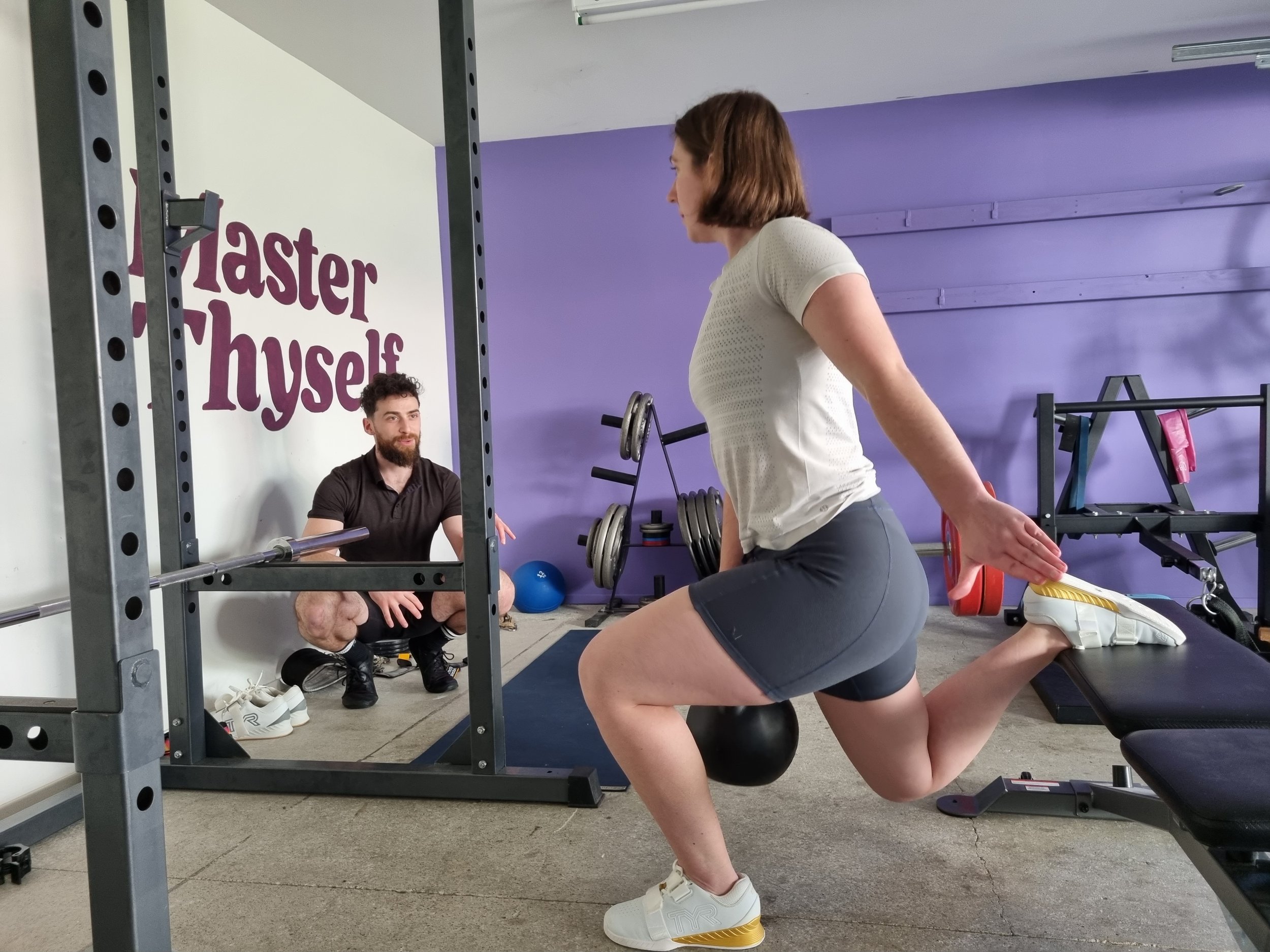 Karori personal trainer instructing female client on weight lifting with a kettle bell