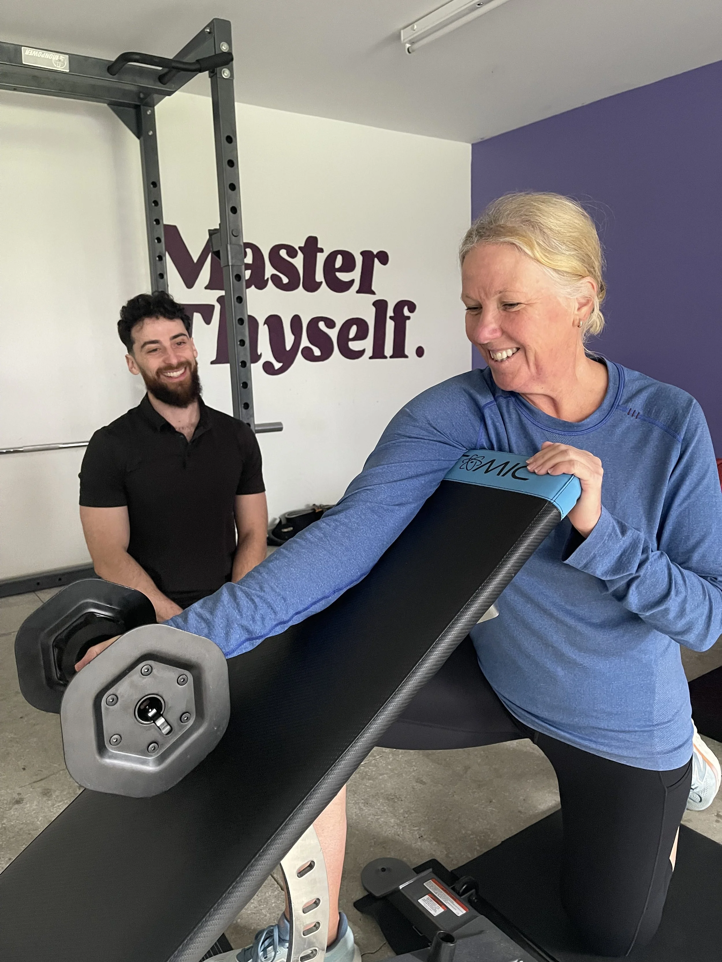 Karori-based personal trainer instructing a female client on weight training with a dumbell