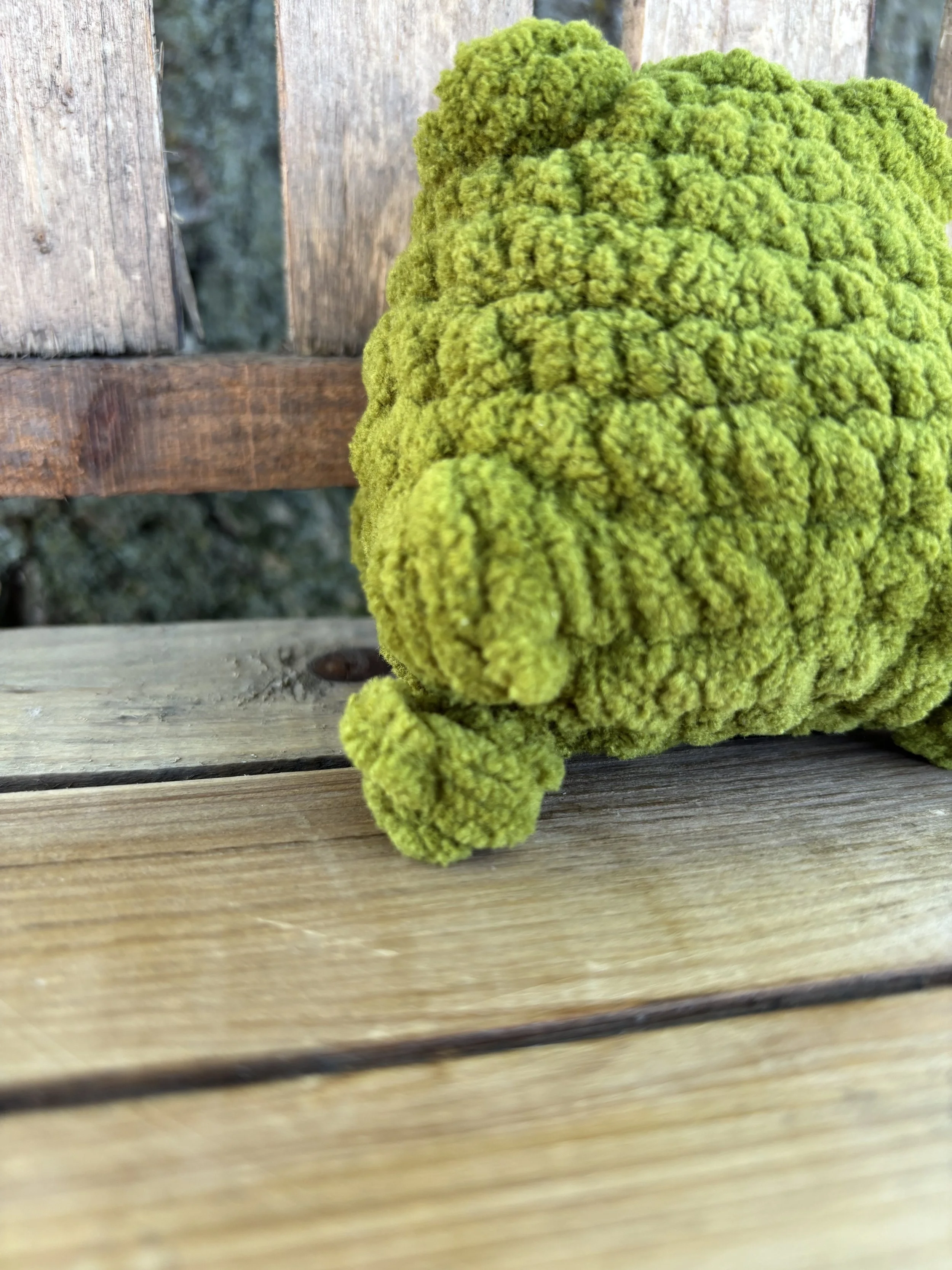 Close up of crochet jumping frog plushie leg