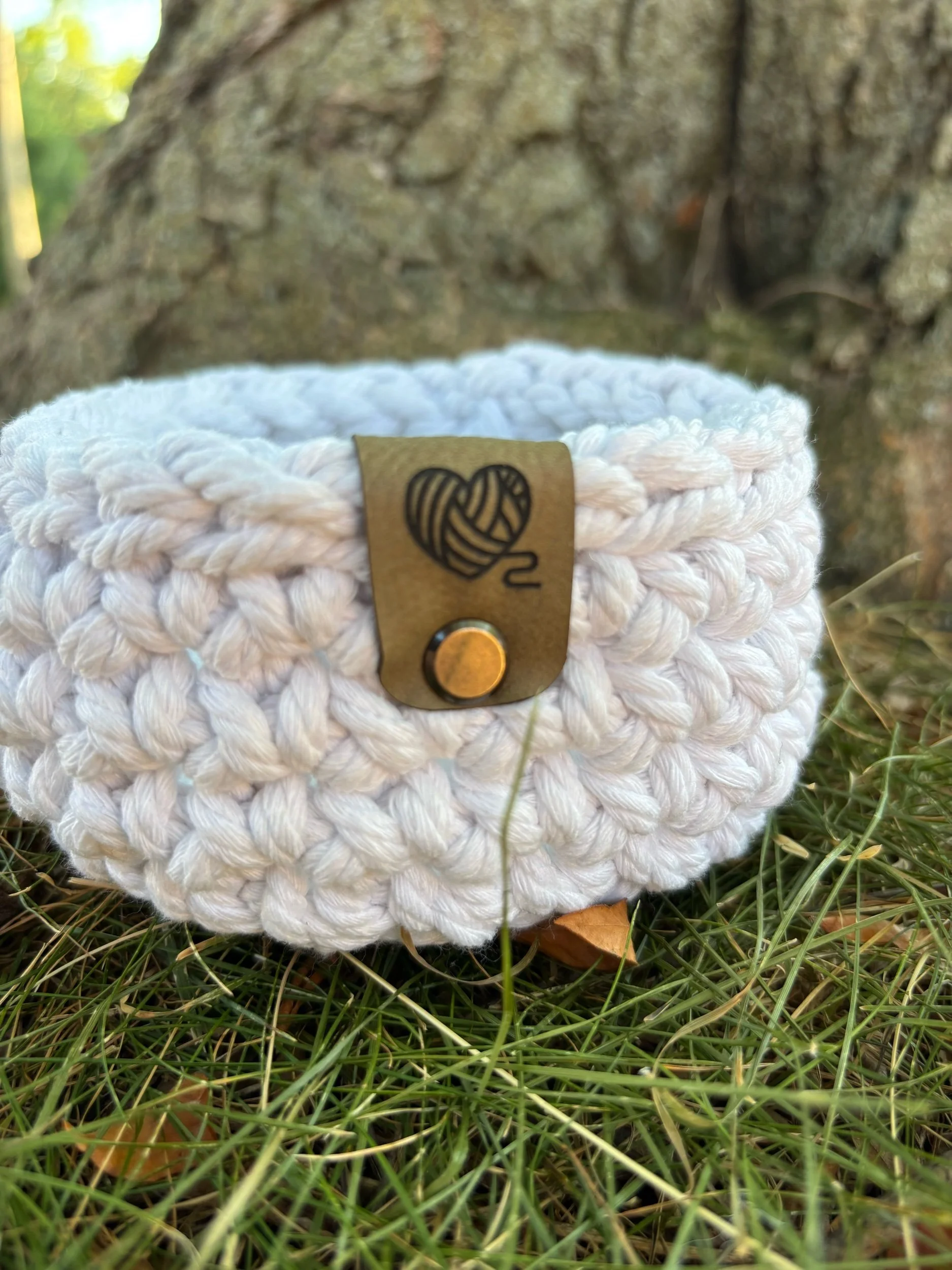 Close up of Stitches by Becca leather tag on natural basket
