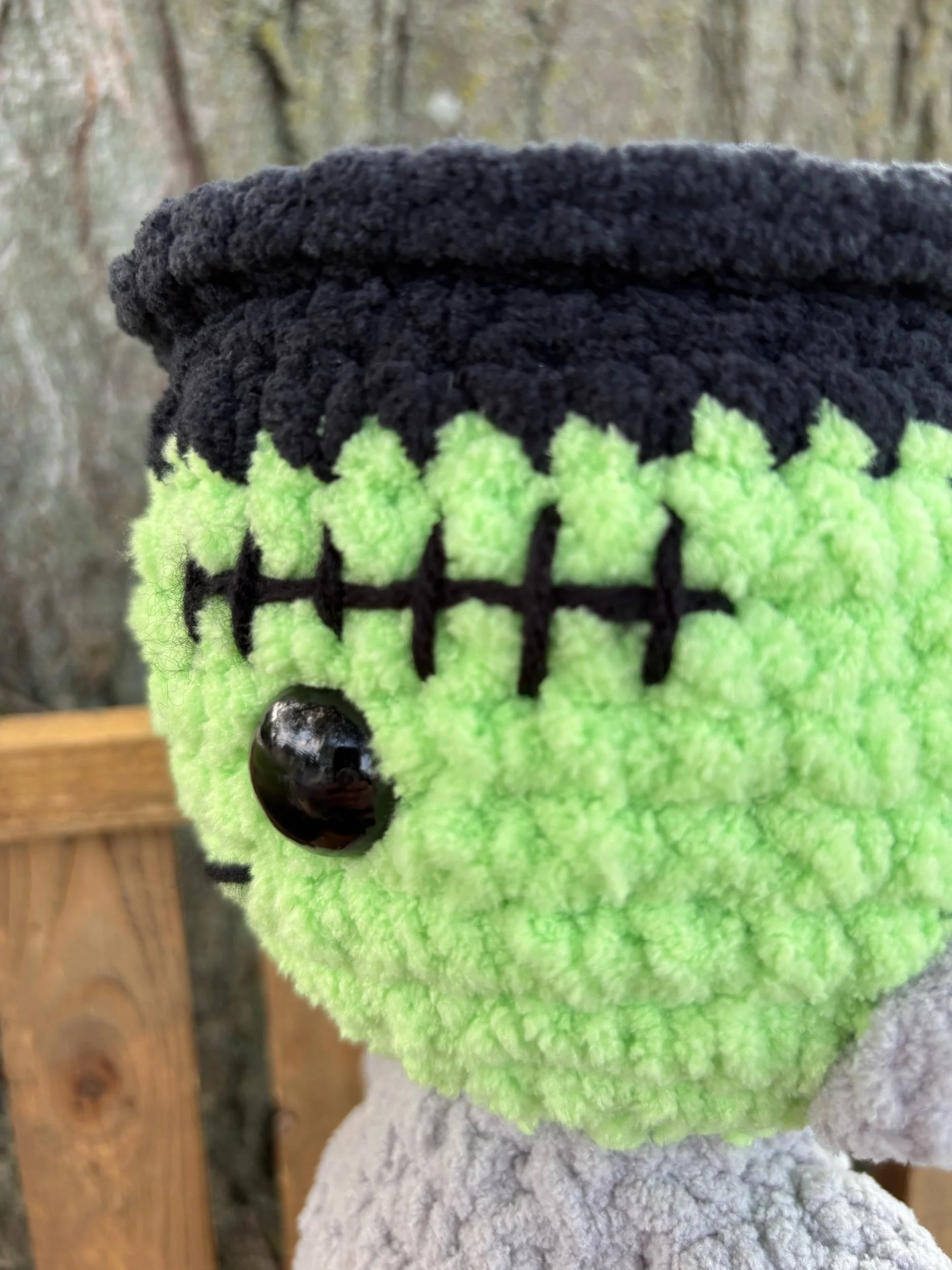 Close up of crochet Frankenstein monster plushie face and stitch scar