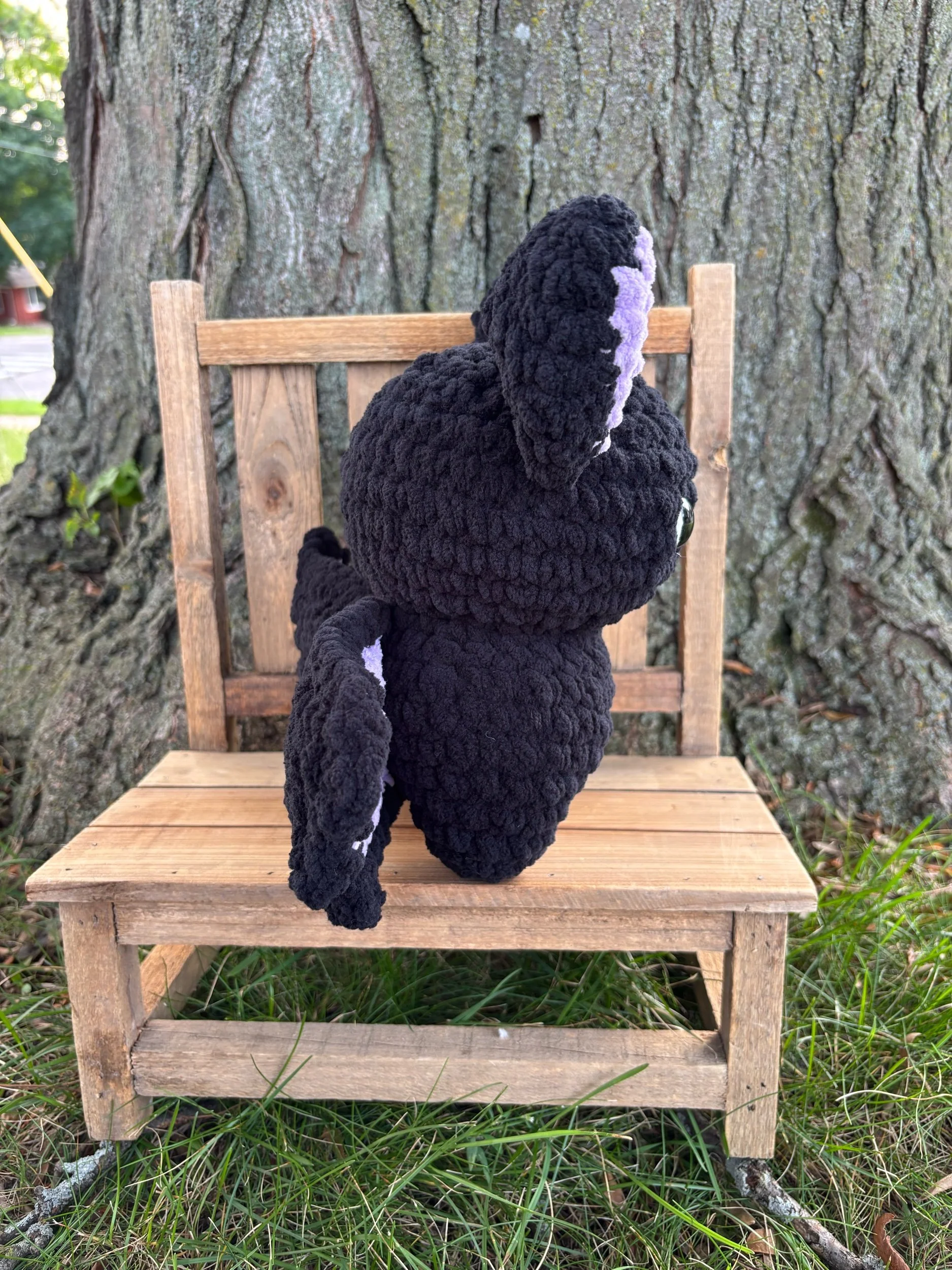 Side view of crochet bat plushie showing wing and ear detail