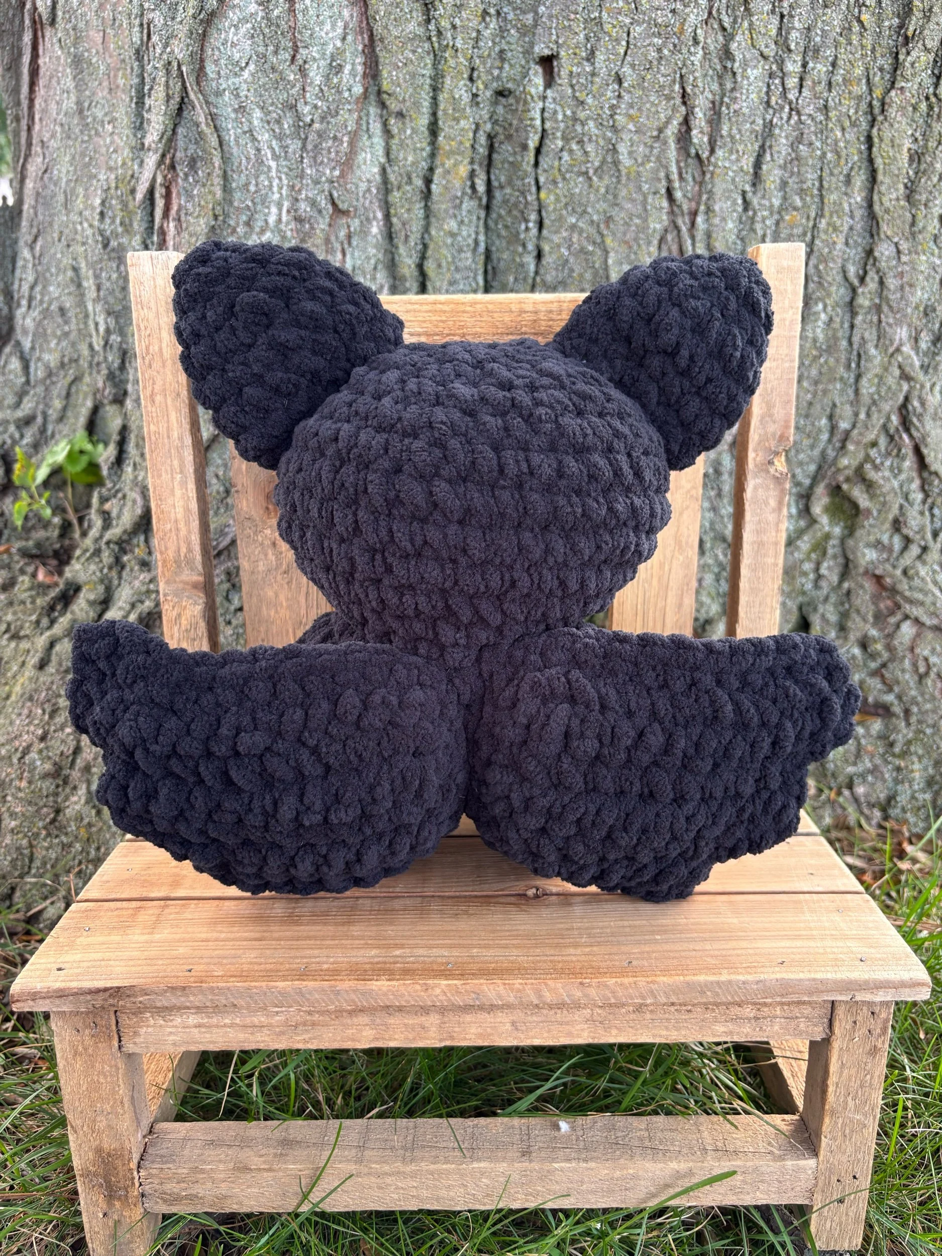 Back of crochet bat plushie showing wings and ears