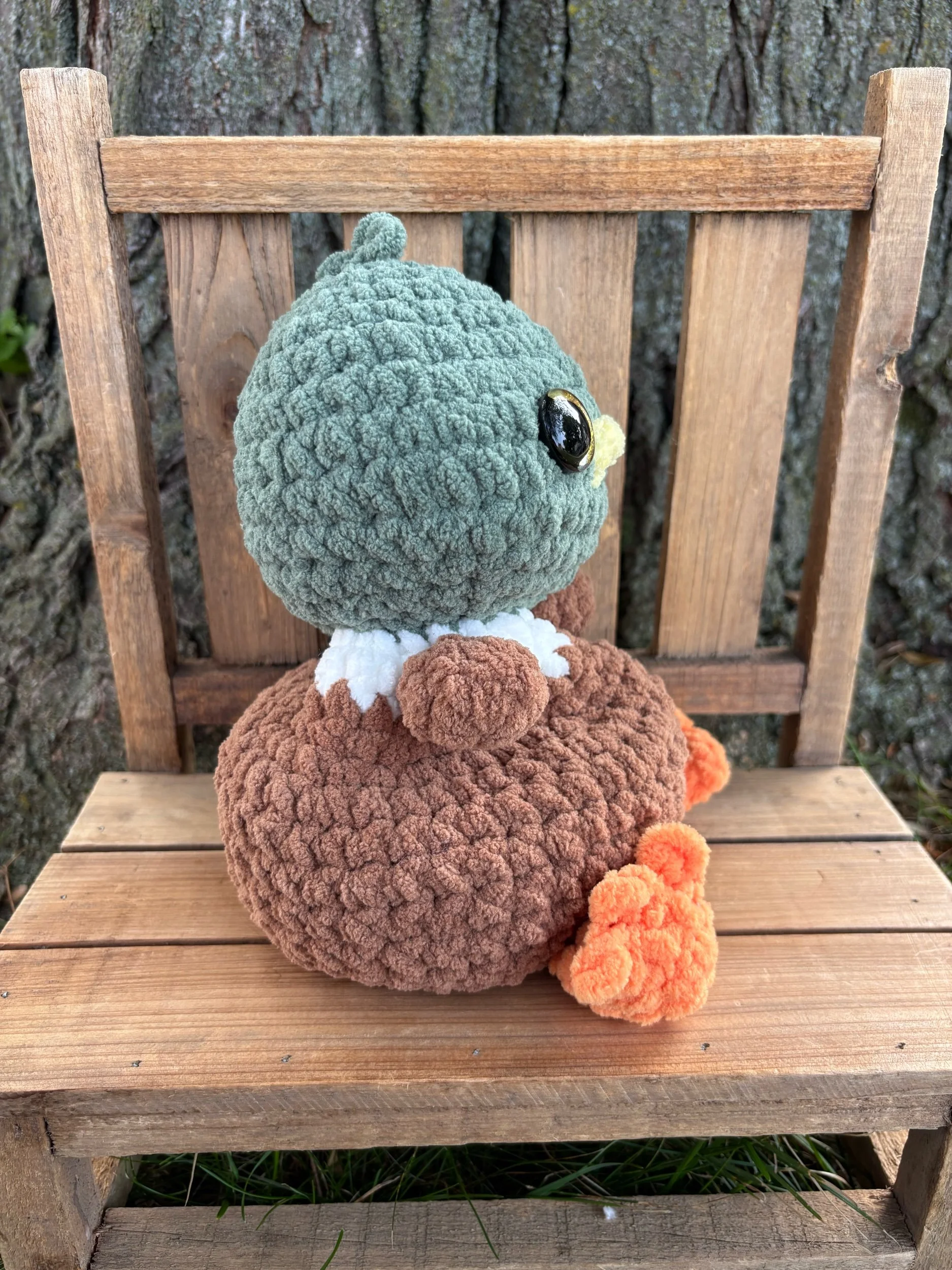 Side view of crochet weighted mallard duck plushie showing feet