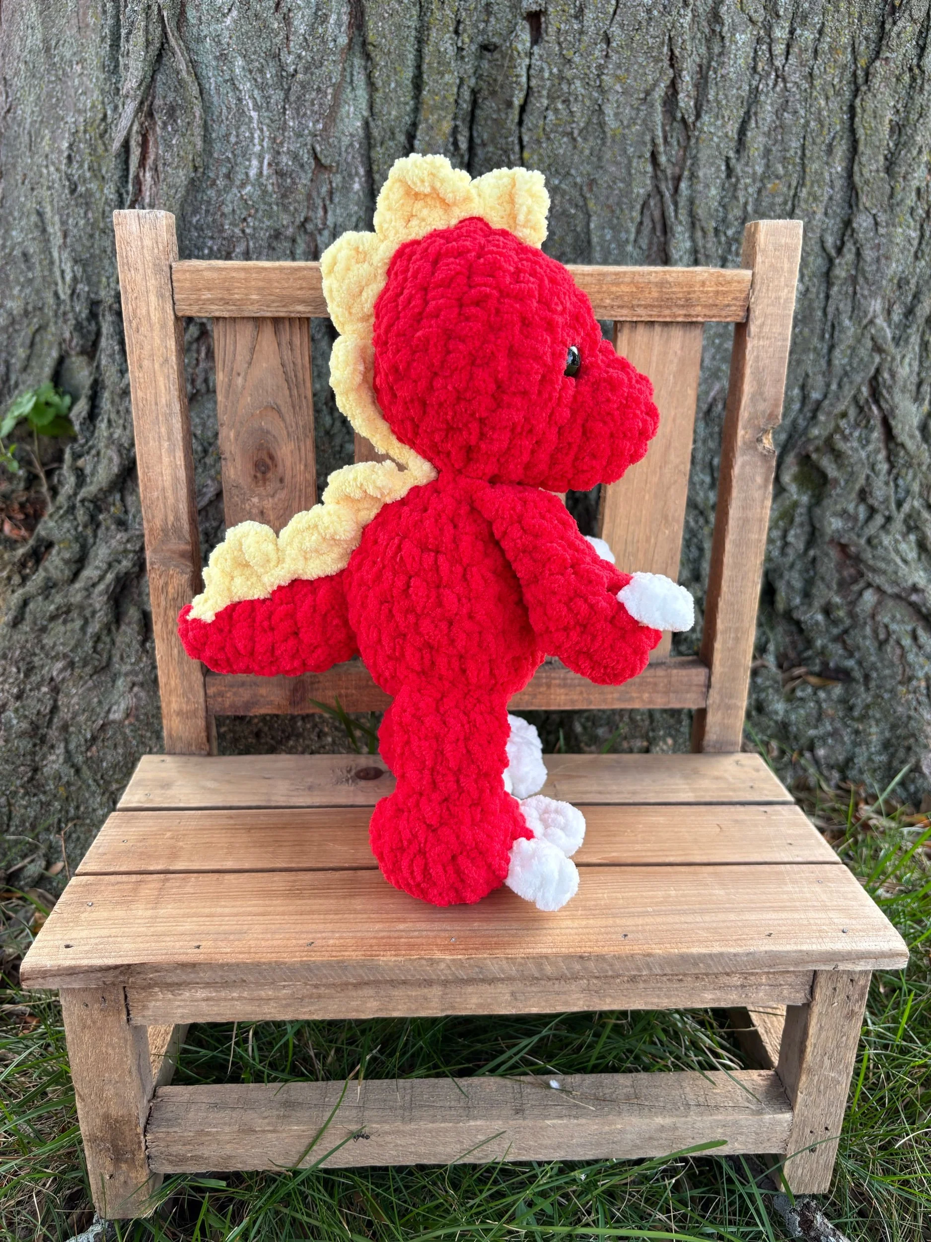 Handmade crochet T-Rex plushie in red with yellow spiked crest and white paw pads
