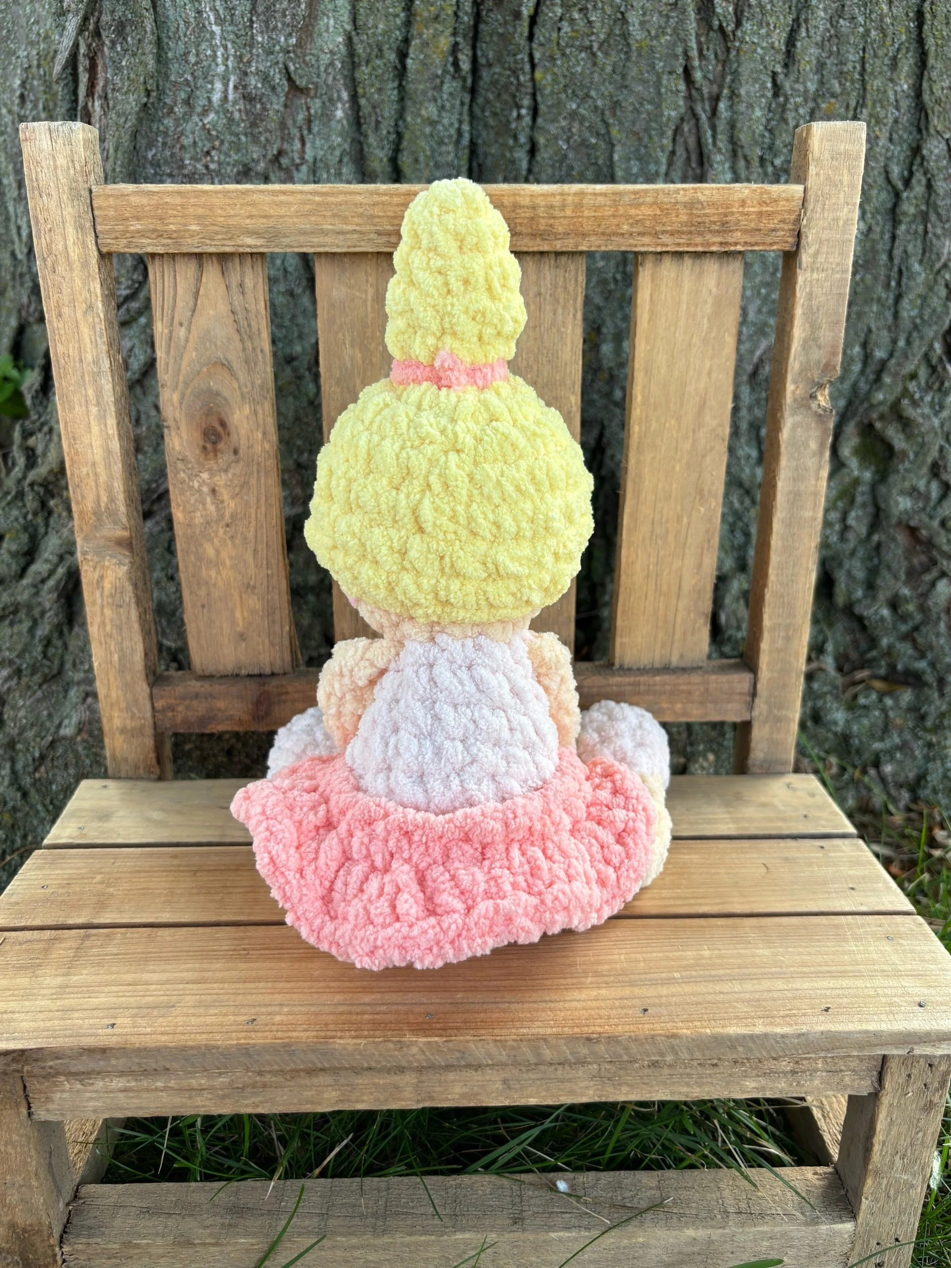 Back view of handmade crochet ballerina doll plushie showing blonde ponytail and pink tutu