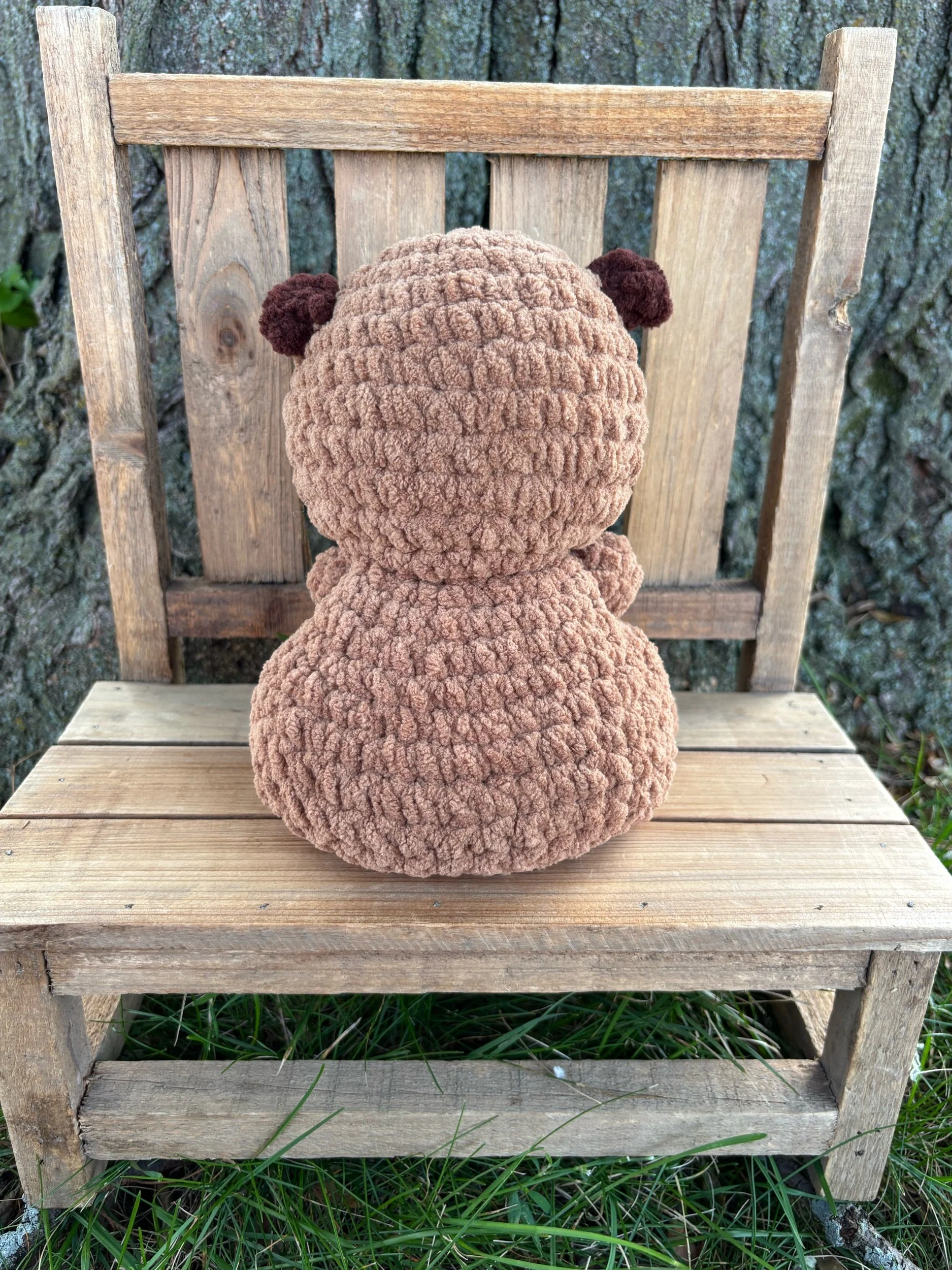 Back view of handmade weighted crochet capybara plushie showing rounded ears