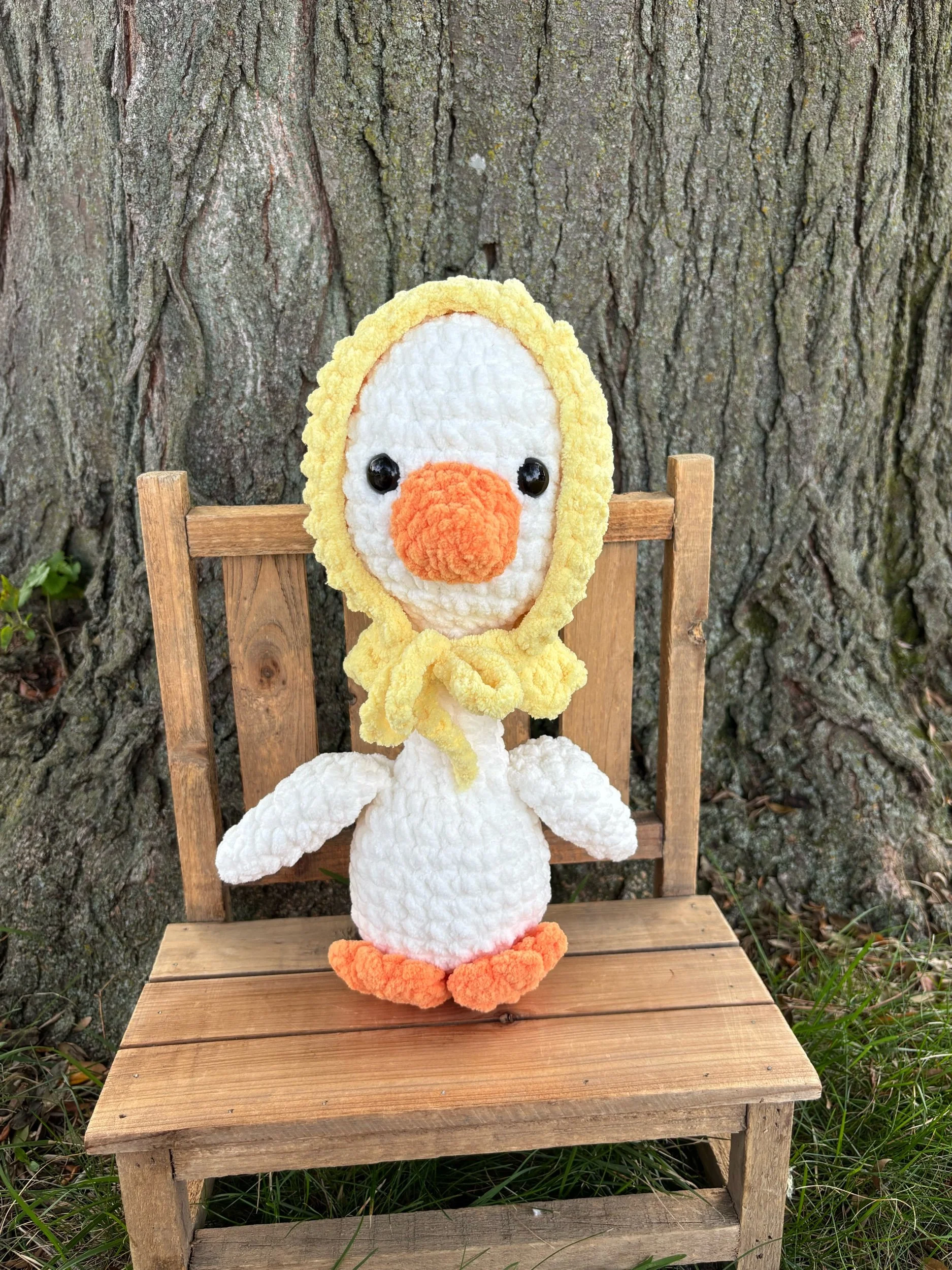 Handmade crochet goose plushie in white with orange bill and yellow tied bonnet