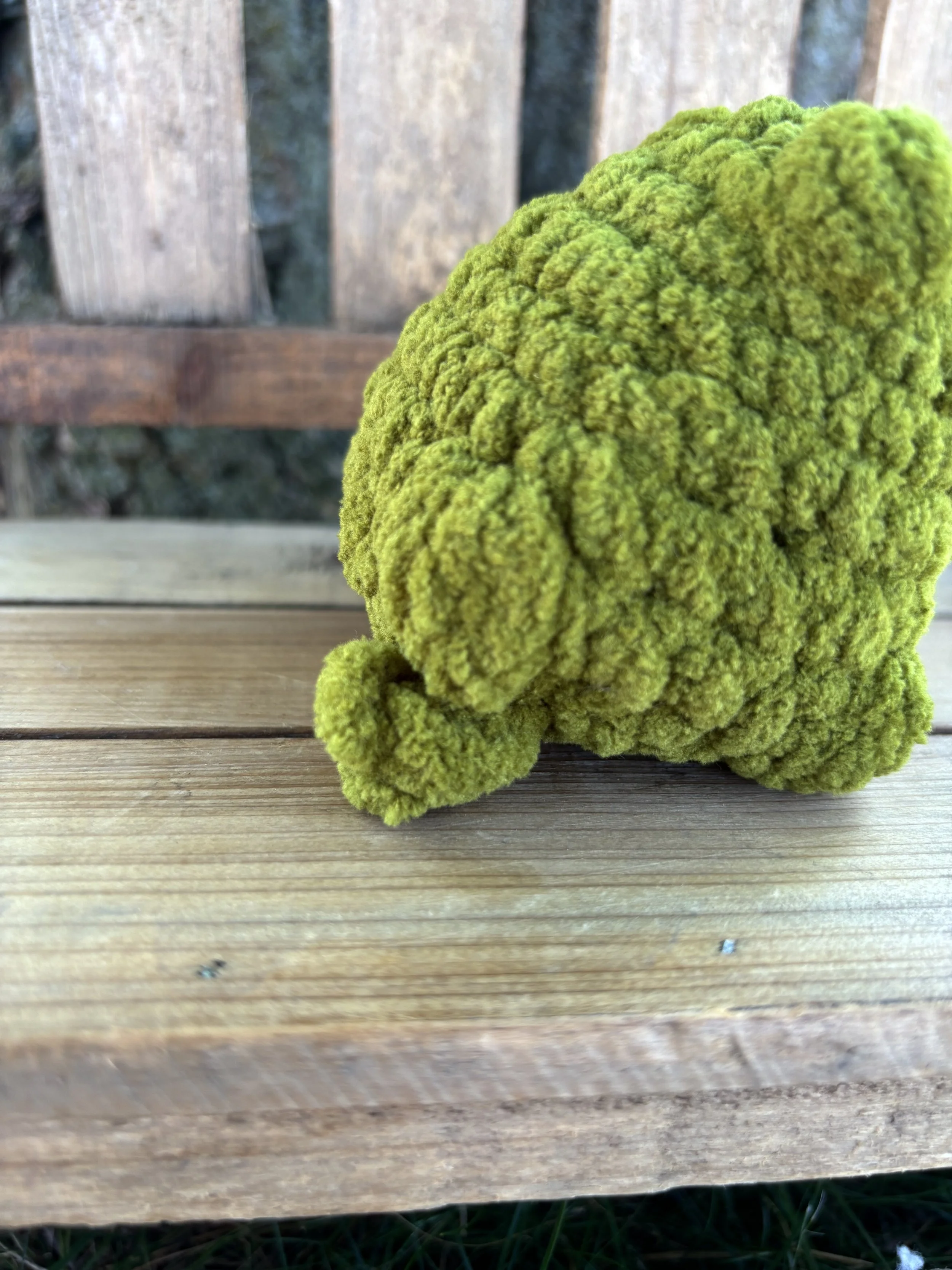 Close up of crochet jumping frog plushie leg