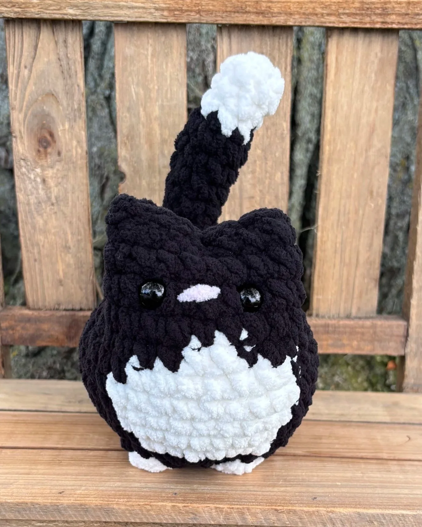 Close up of crochet black tuxedo cat plushie face
