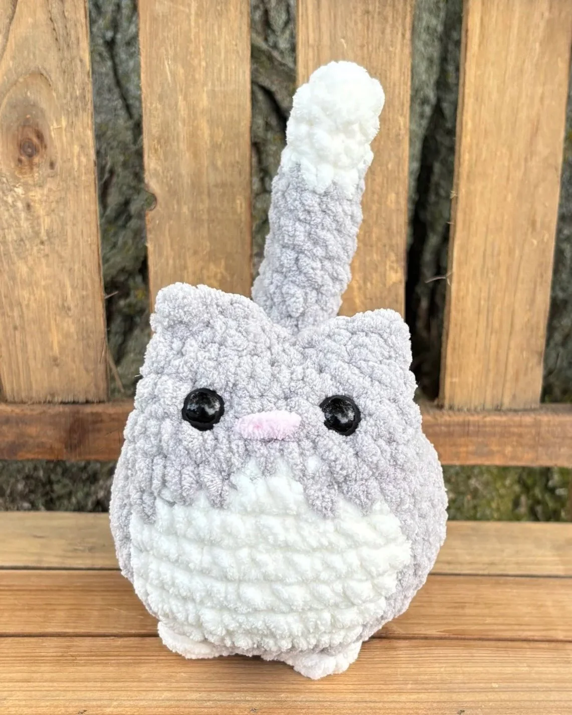 Close up of crochet grey tuxedo cat plushie face
