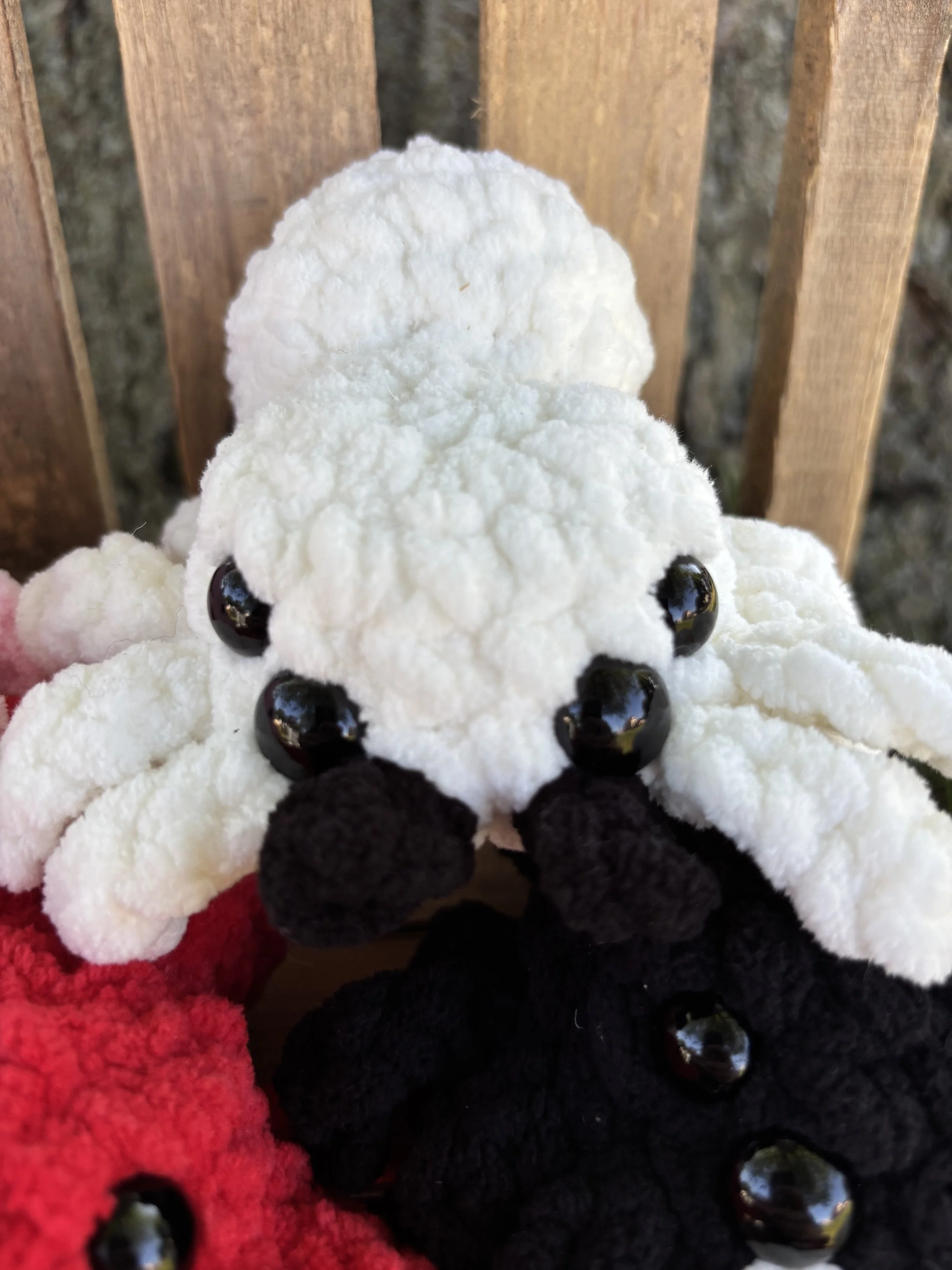 Close up of crochet jumping spider plushie face