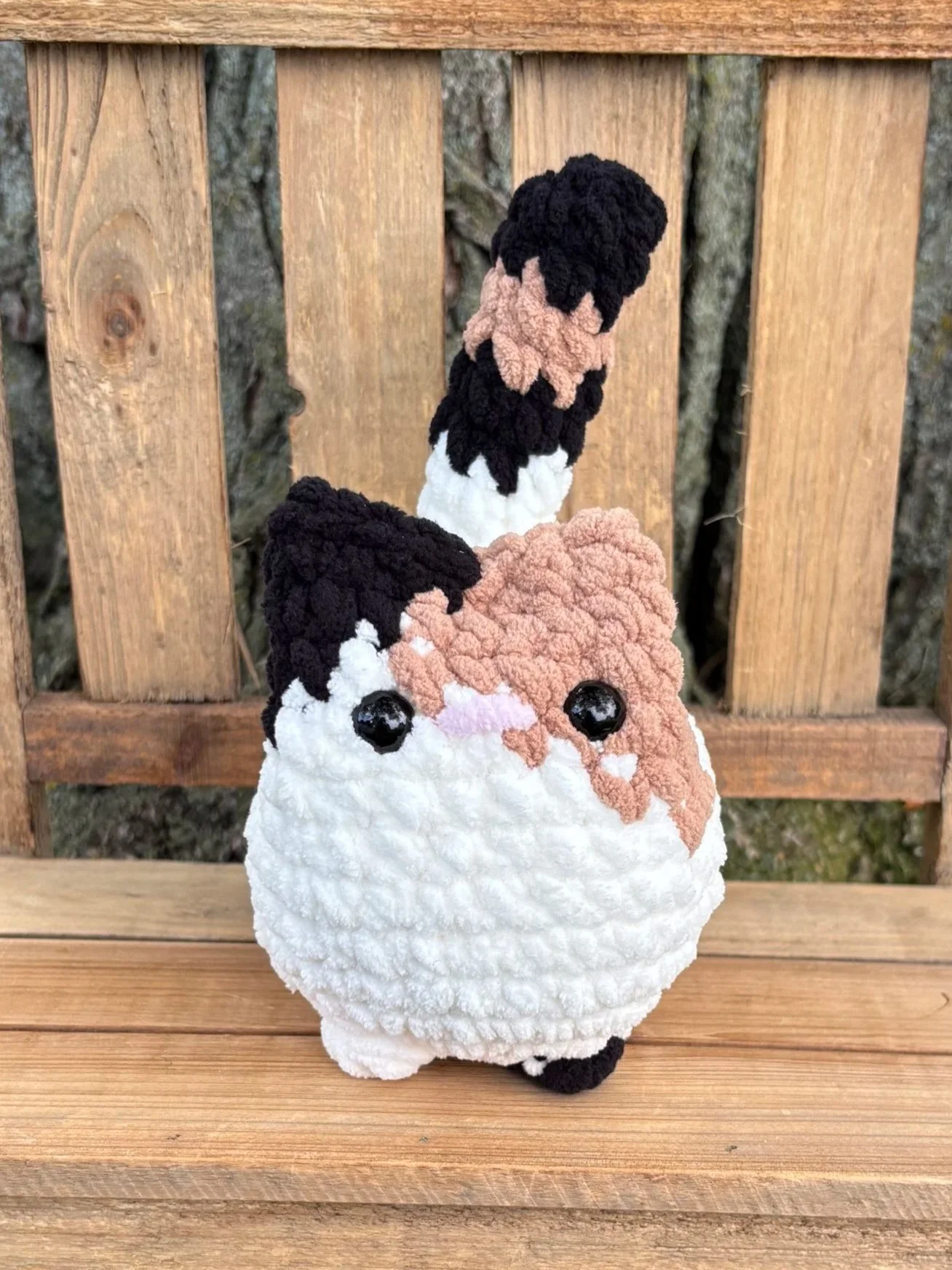 Close up of crochet calico cat plushie face