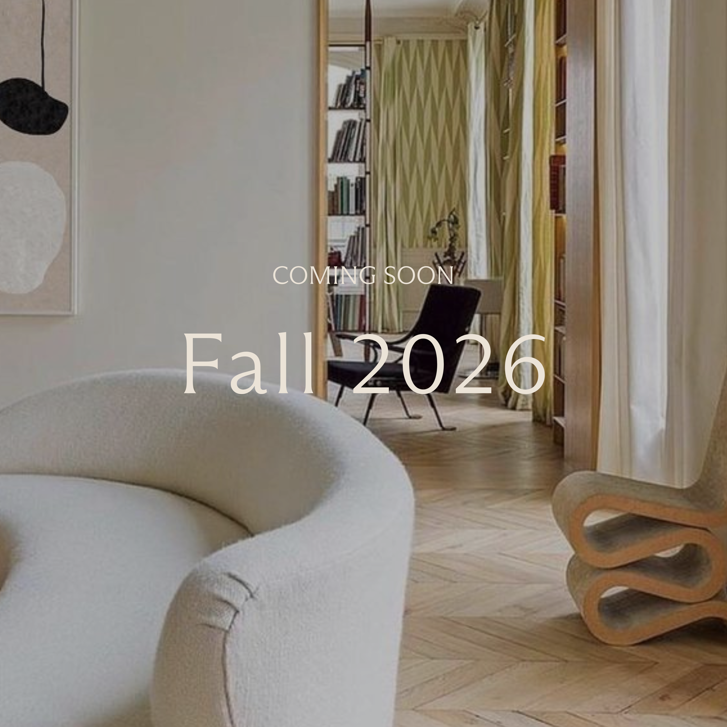 Modern living room with cream sofa, brown chair, glass table, and decorative wooden desk, featuring "Fall 2025 Coming Soon" text. Interior design luxury residential project in Newport Beach California Irvine