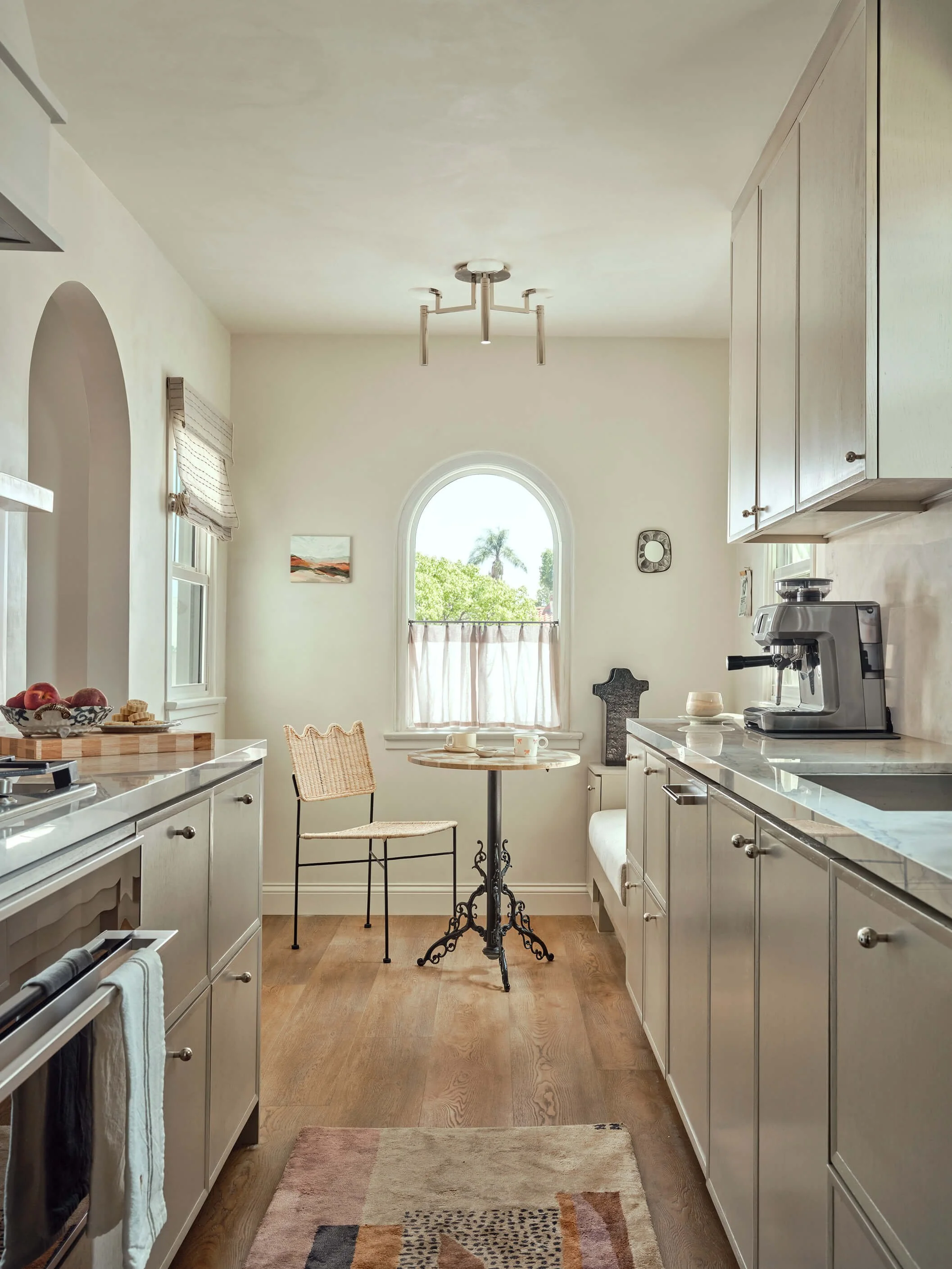 Marble pedestal with a black vase holding white flowers, text "Coming Soon Fall 2025." Interior design luxury residential project in Los Angeles