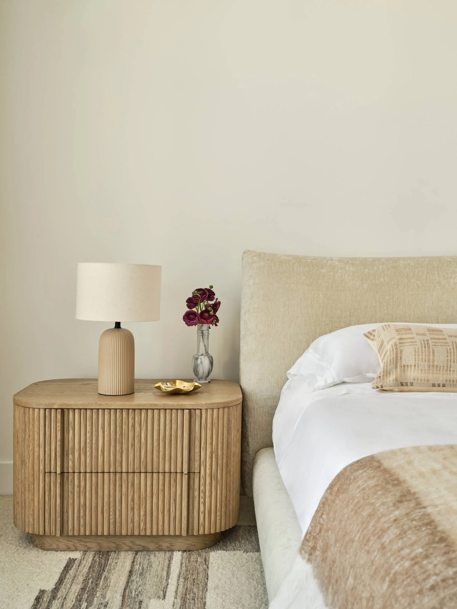 Edra's Stand By Me bed frame paired with a neutral wood fluted nightstand. 