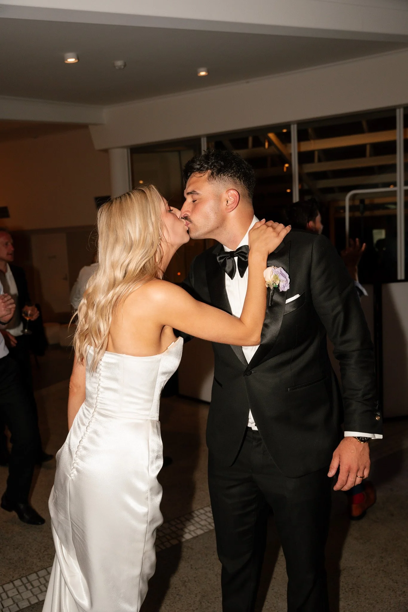 A bride and groom kiss at their wedding reception.