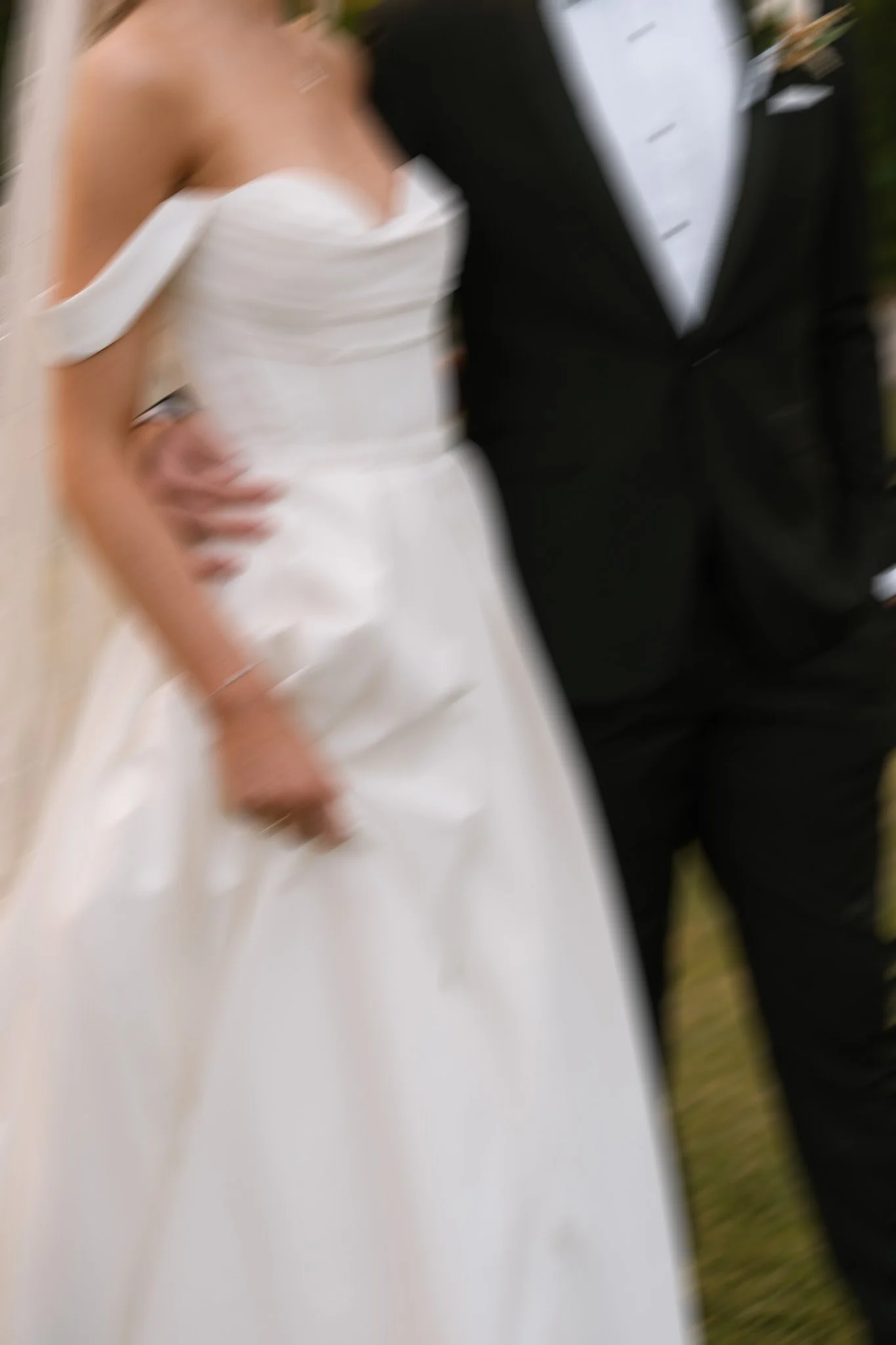 A blurry photo of a bride in a white wedding dress and a groom in a black suit.