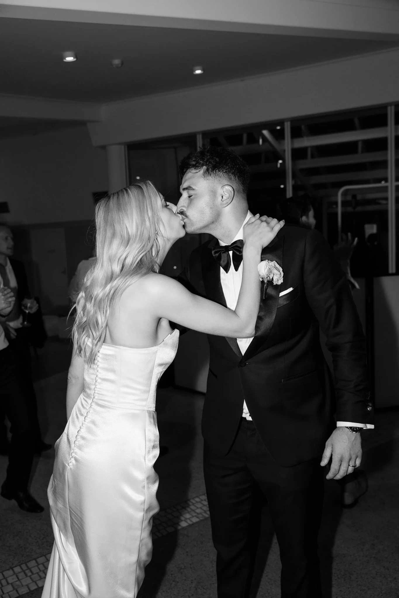 A bride and groom sharing a kiss during their wedding celebration.