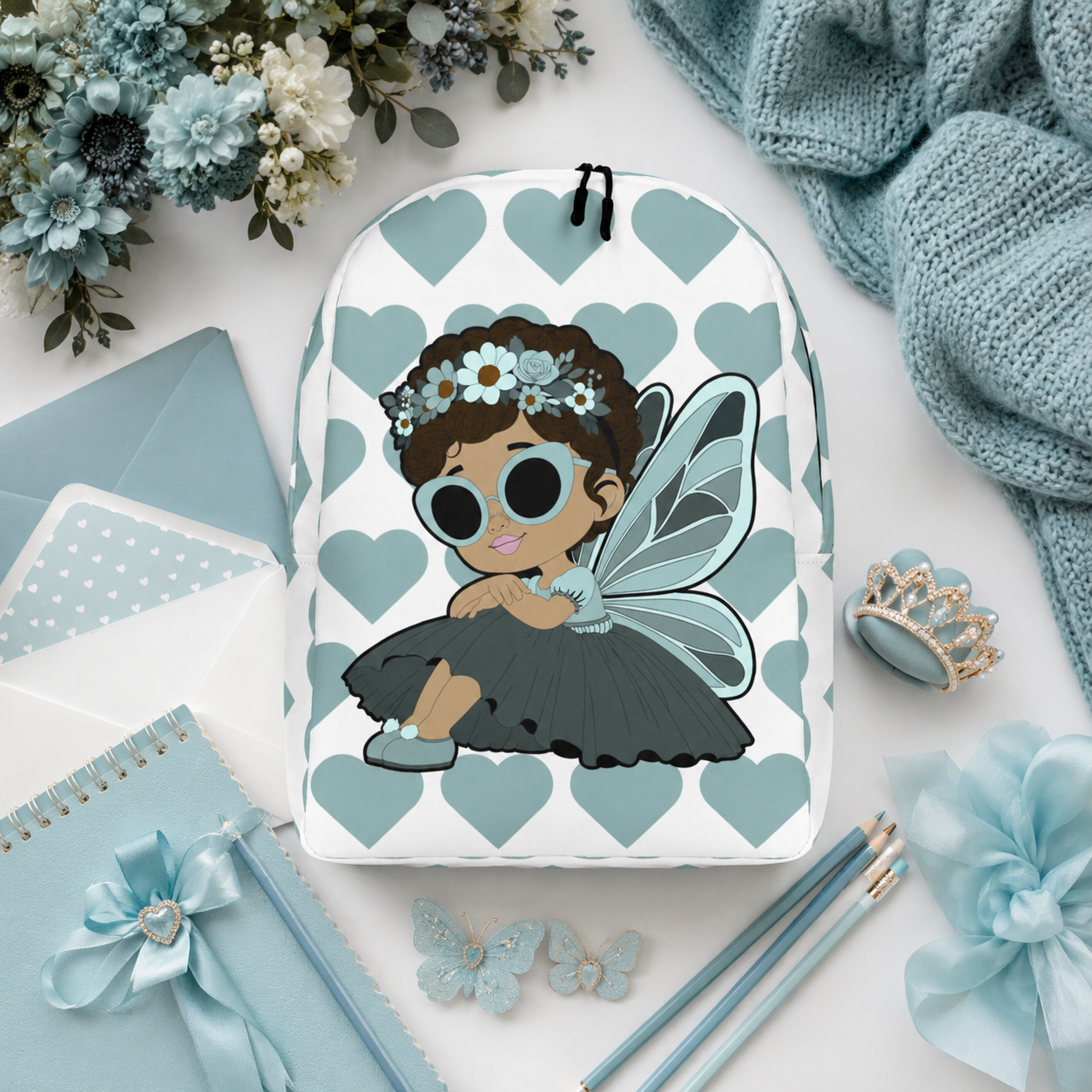 Coco Pixies Pixie Piper Backpack featuring a Black girl pixie, aqua hearts, sunglasses, and floral details
