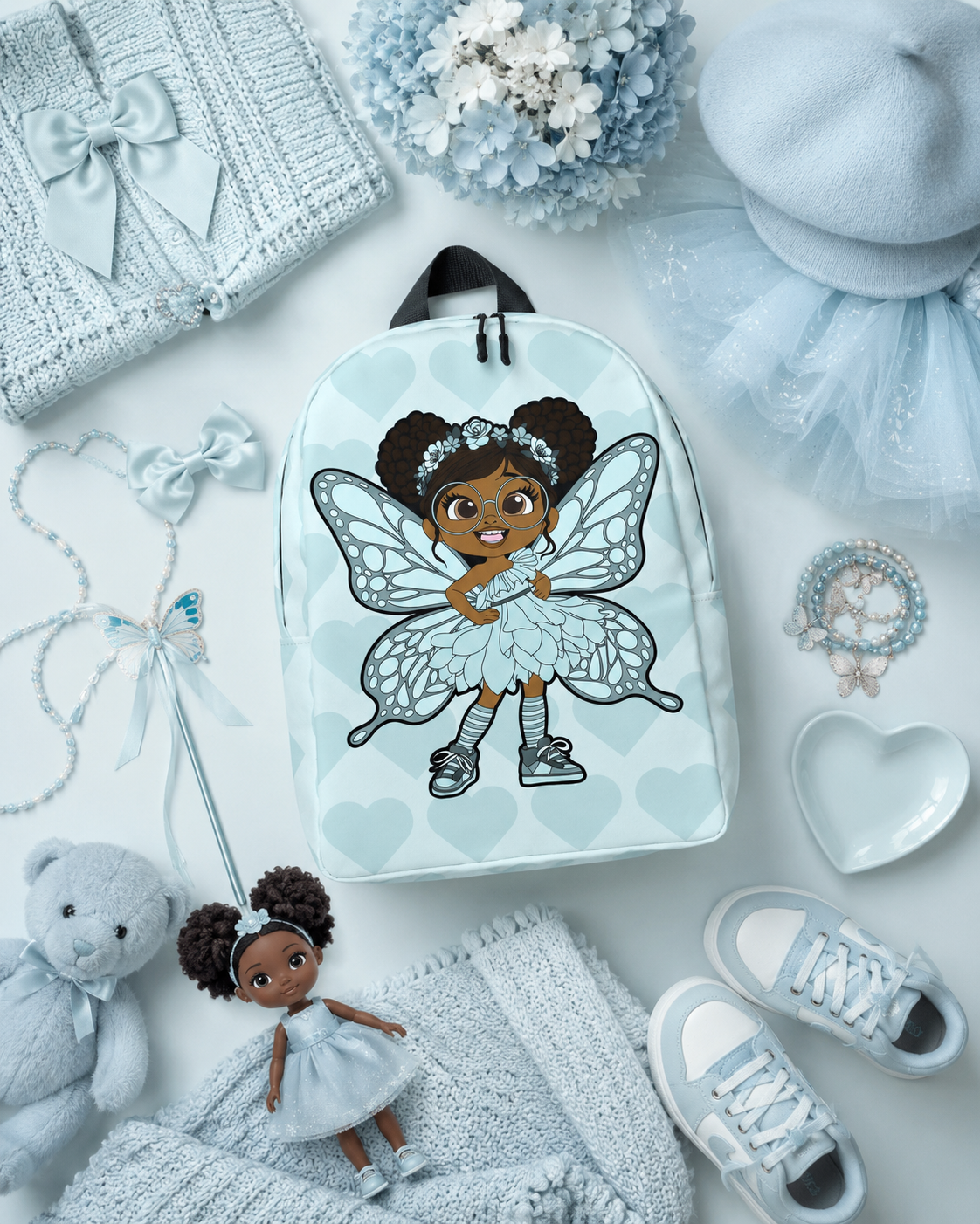 Coco Pixies JoJo Jollypuff backpack featuring afro puffs, round glasses, baby cyan wings, and heart pattern