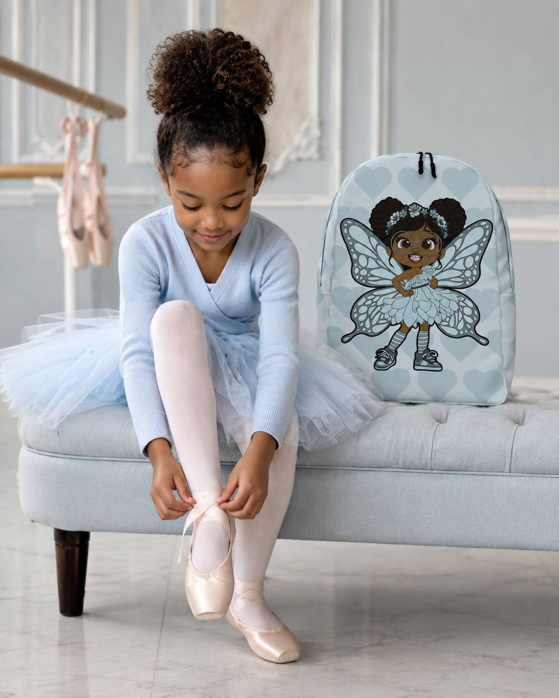 Coco Pixies JoJo Jollypuff backpack featuring afro puffs, round glasses, baby cyan wings, and heart pattern