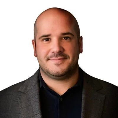 Portrait of a man in a suit with a white background.