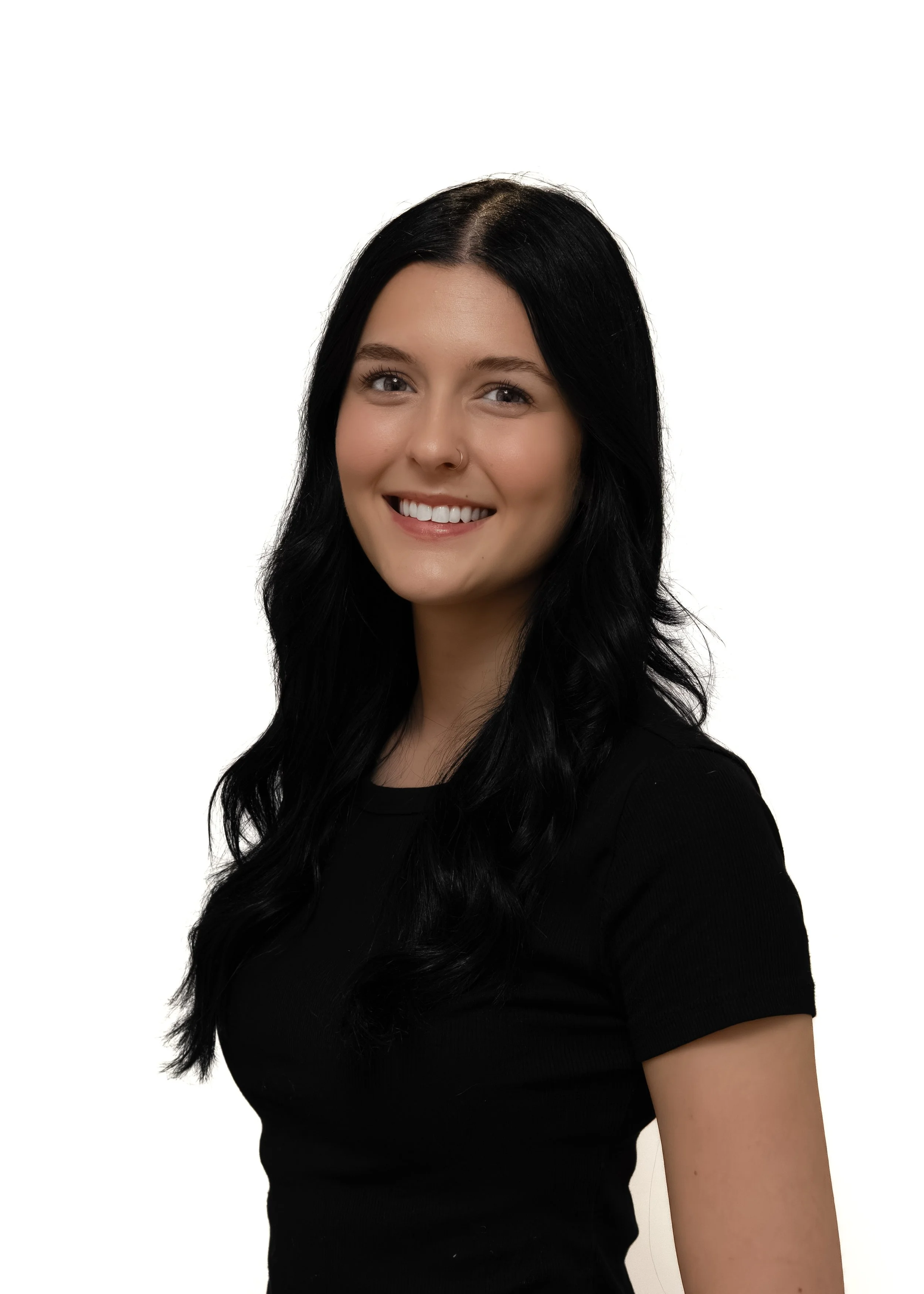 Portrait of a young woman with long, black hair, smiling, wearing a black top, against a plain white background.