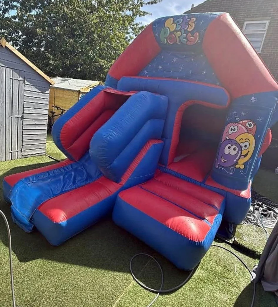 Colourful inflatable bounce house with slide in blue and red