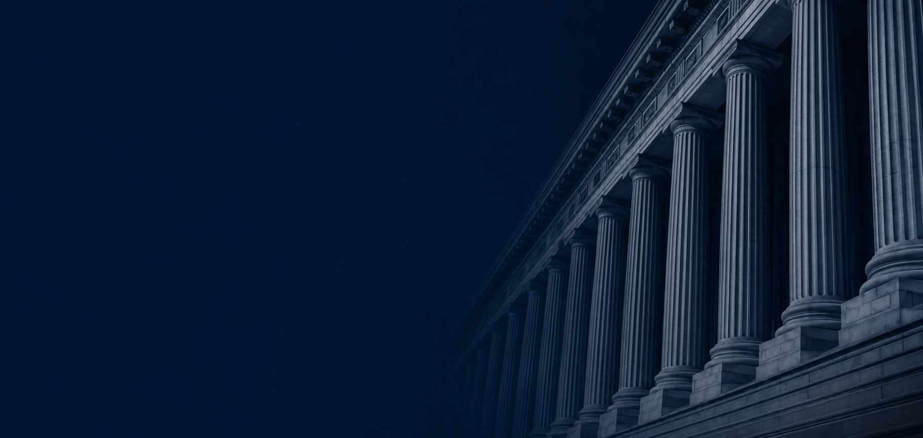 A nighttime view of a neoclassical building with large columns in Washington, D.C.