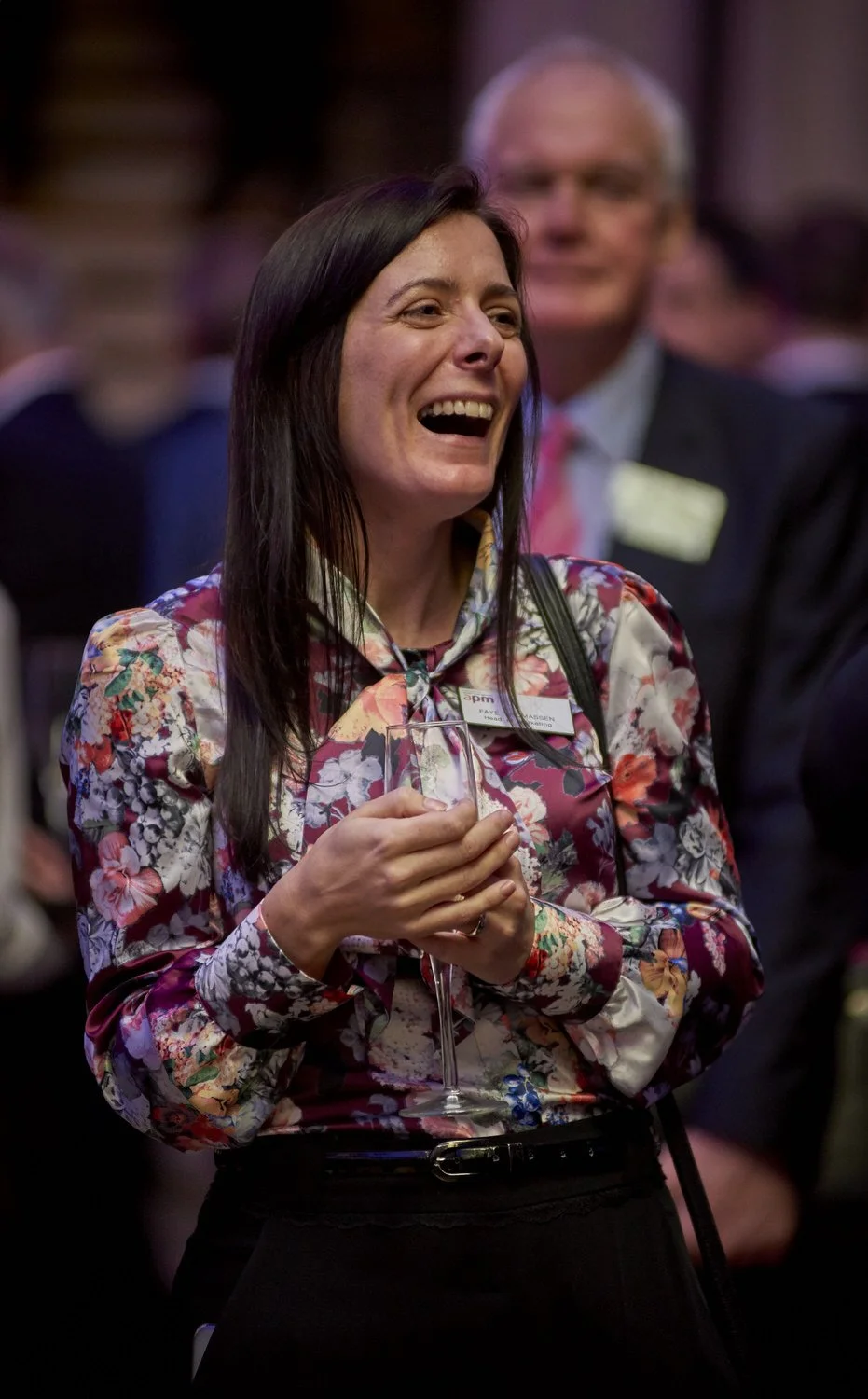 Lady laughing with colleagues in a busy networking room.