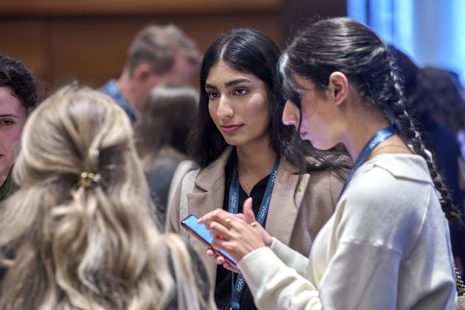 Women in crowd networking at business event.