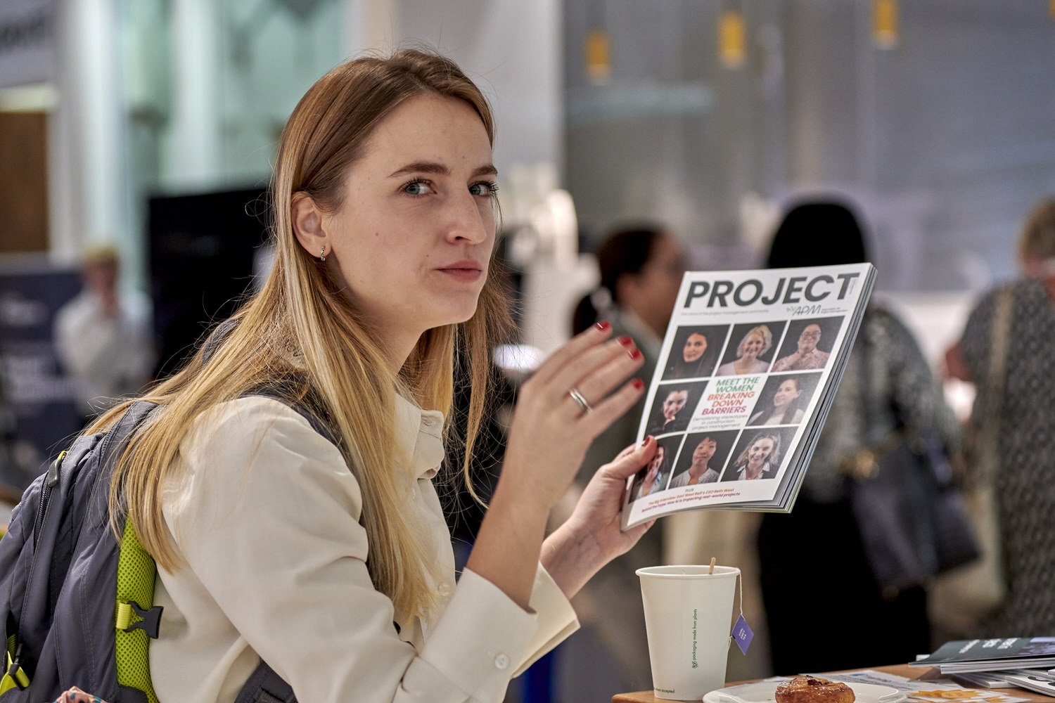 Lady looking at the camera while reading project literature at a conference.