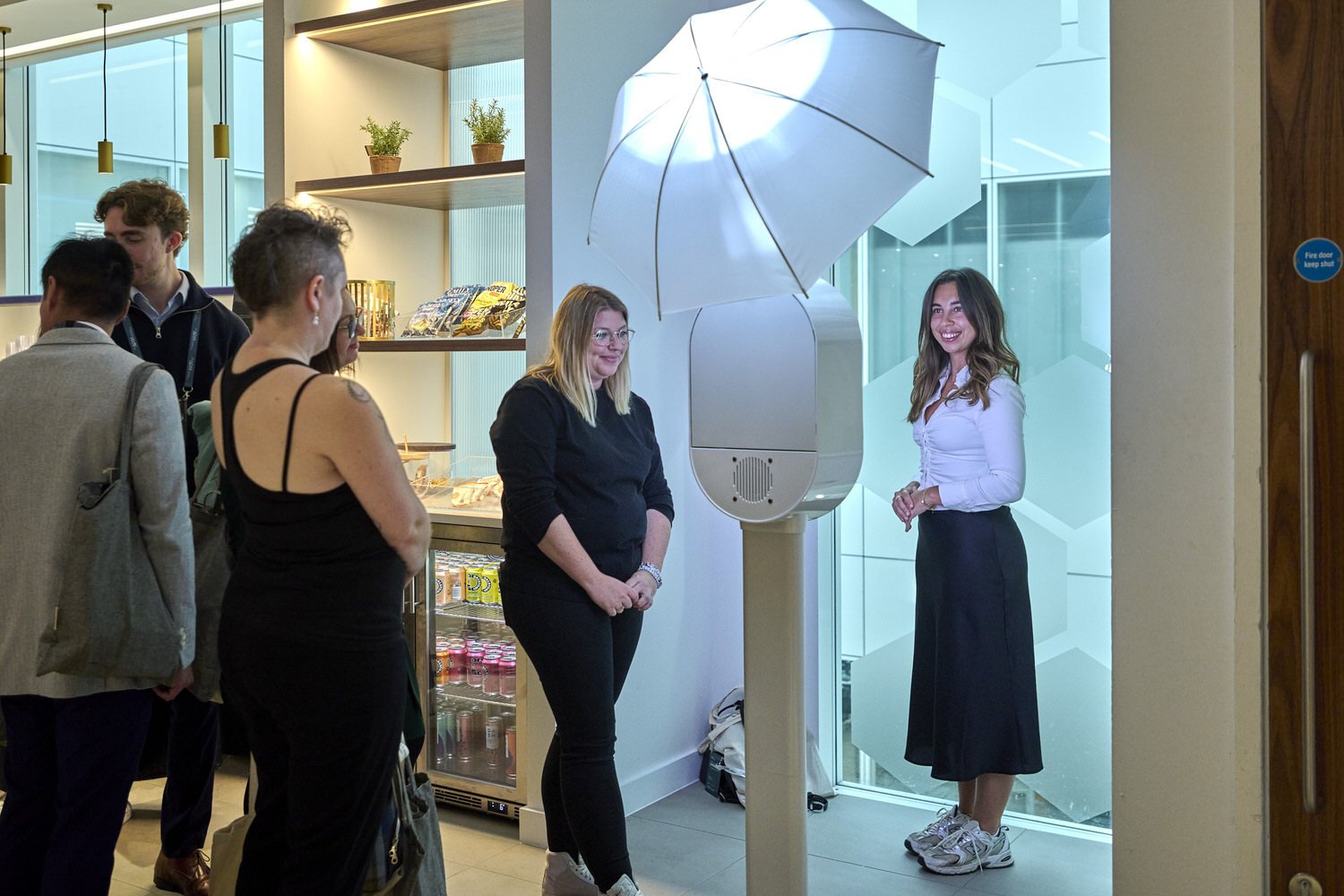 Wide view of attendees using a selfie machine to take group photos.