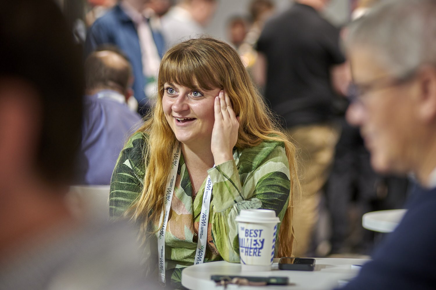 Lady in the audience smiling while listening to a speaker.