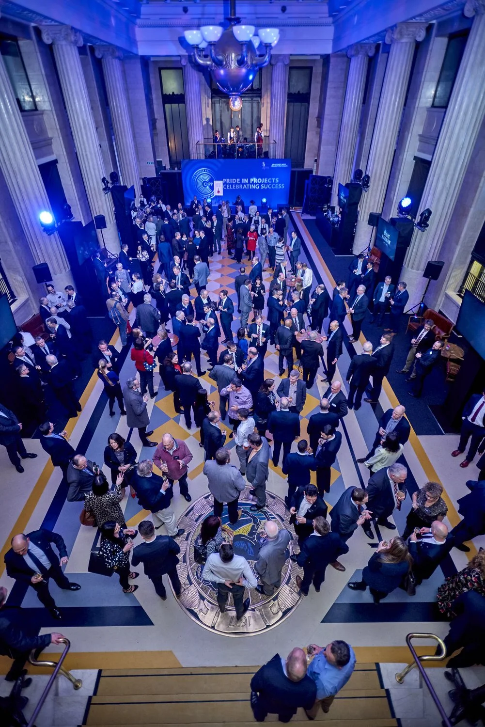 Large conference hall with pillars and crown detail photographed from above.