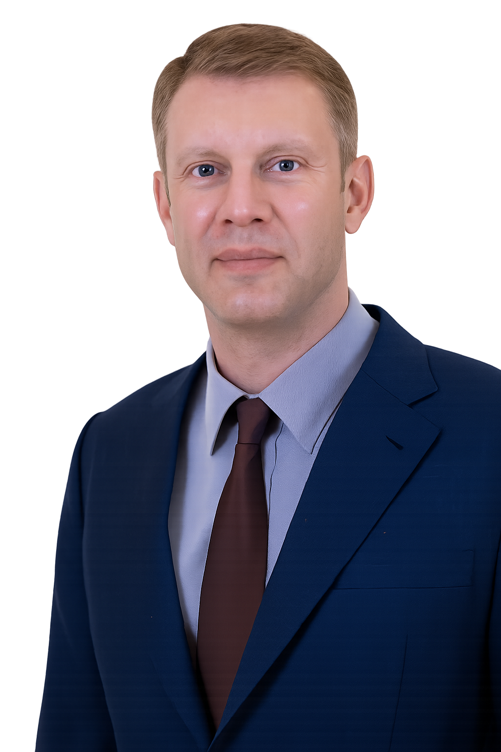 A professional portrait of a man in a dark blue suit, light blue dress shirt, and brown tie, against a dark background with some colorful lights.