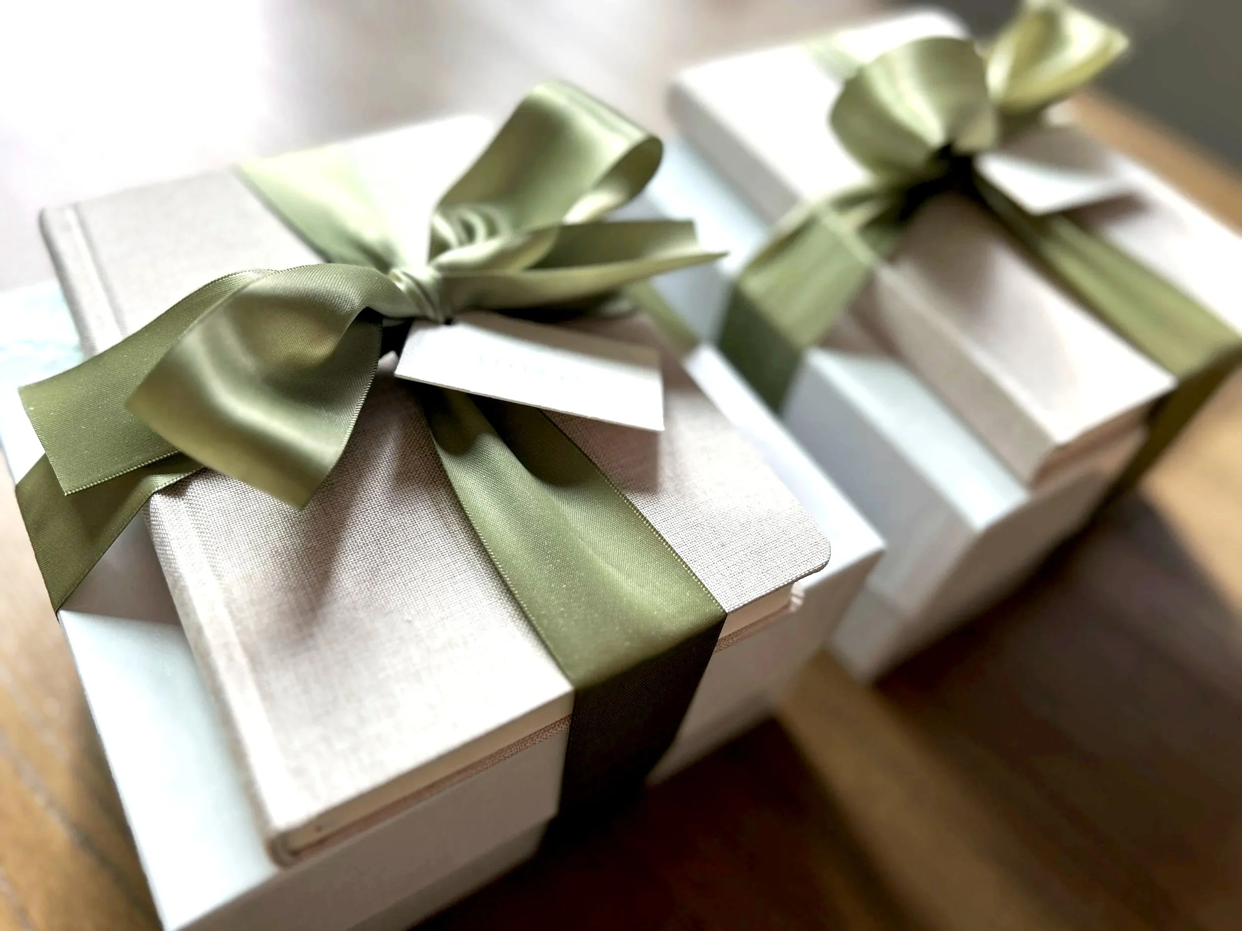 A gift box containing a a ceramic travel mug vanilla latte mug cake vanilla & coffee bean travel candle all placed in a gift box with ivory crinkle paper