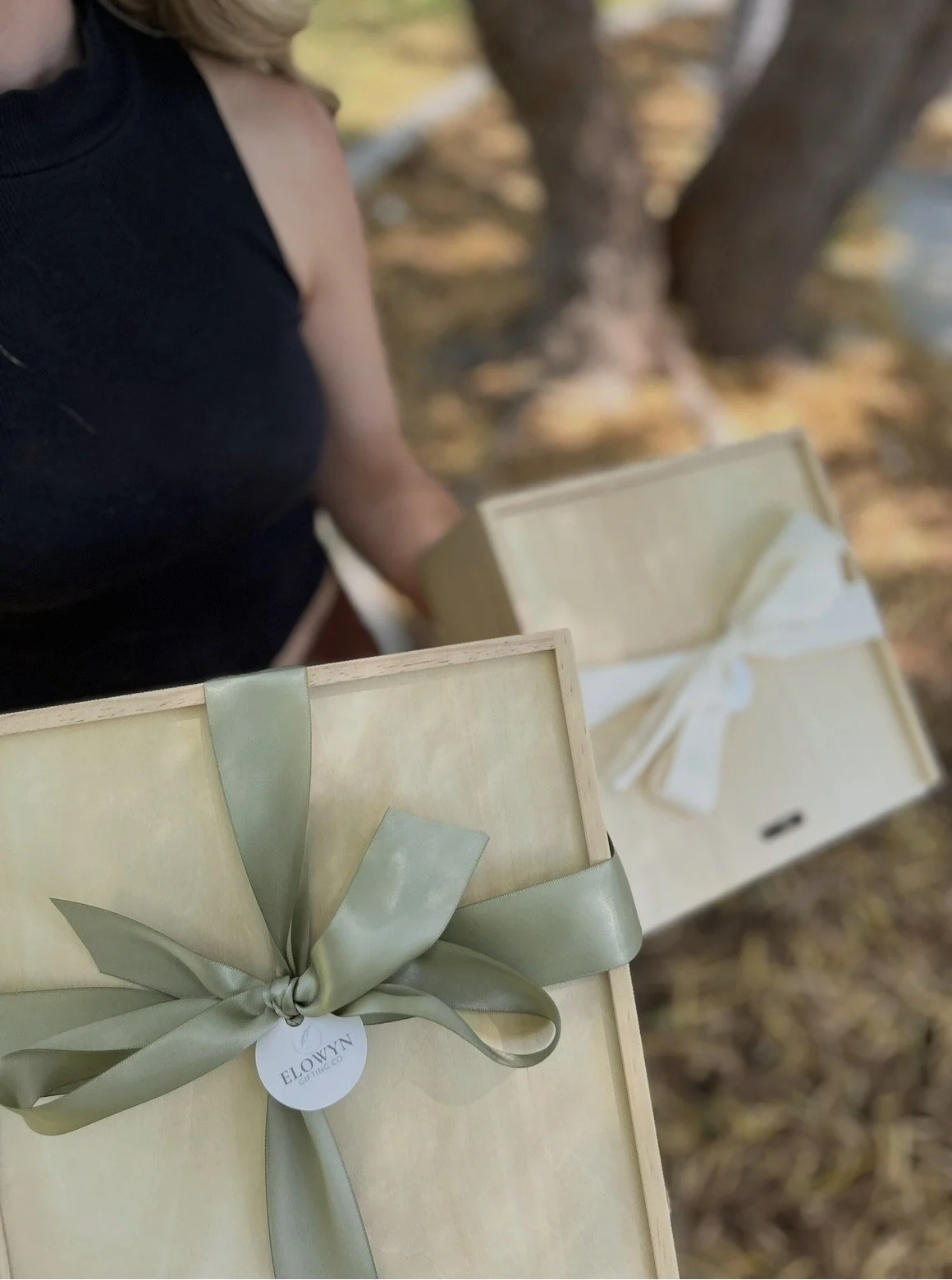 Several dark blue gift bags lined up on a table